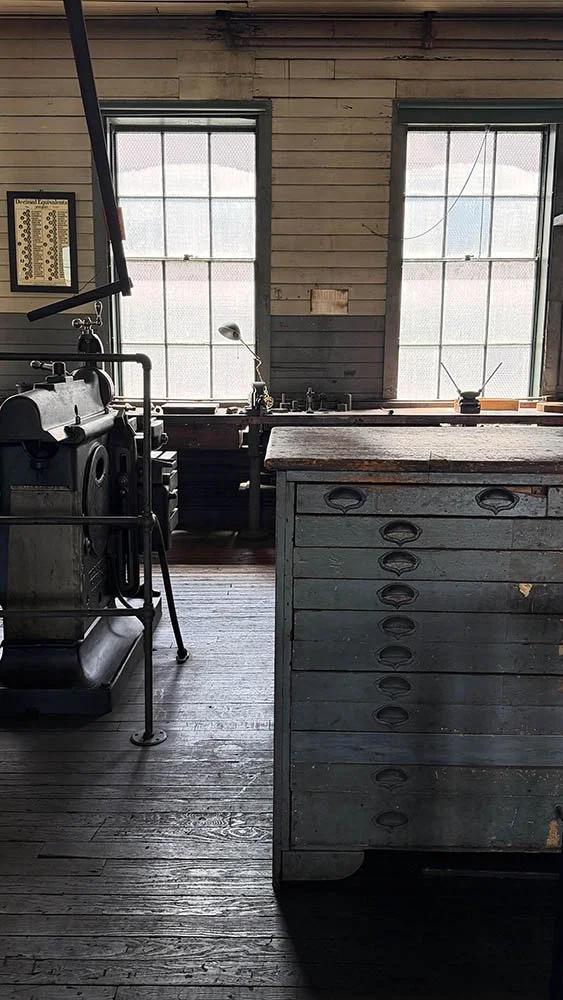 Weathered wooden filing drawers inside Edison's machine shop, worn from decades of use
