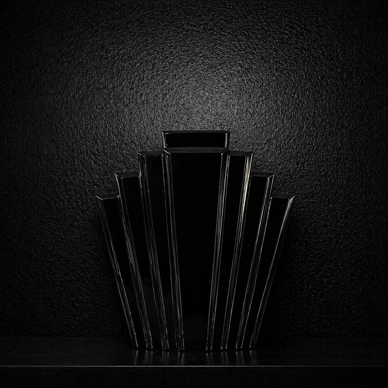Black geometric fan-shaped vase against a black wall, 1980s postmodern glam decor