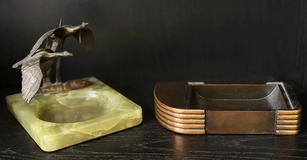 Streamline Moderne copper ashtray beside brass birds on a green onyx ashtray base