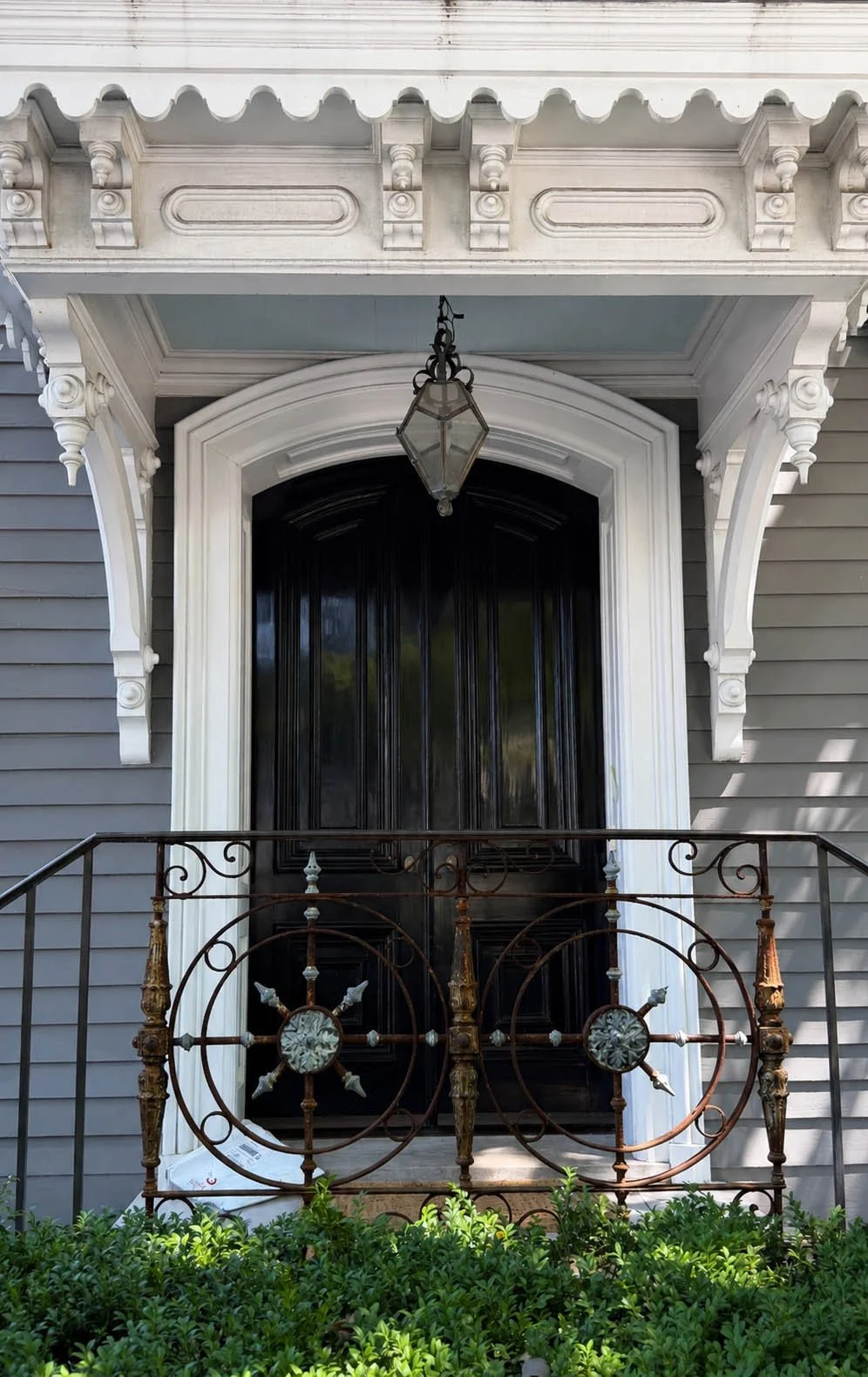 Close up of a wrought iron entryway gate with starburst medallions and visible rust detail