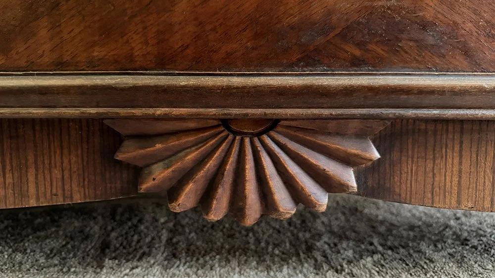 Carved wooden fan detail on the base of a vintage Lane cedar chest