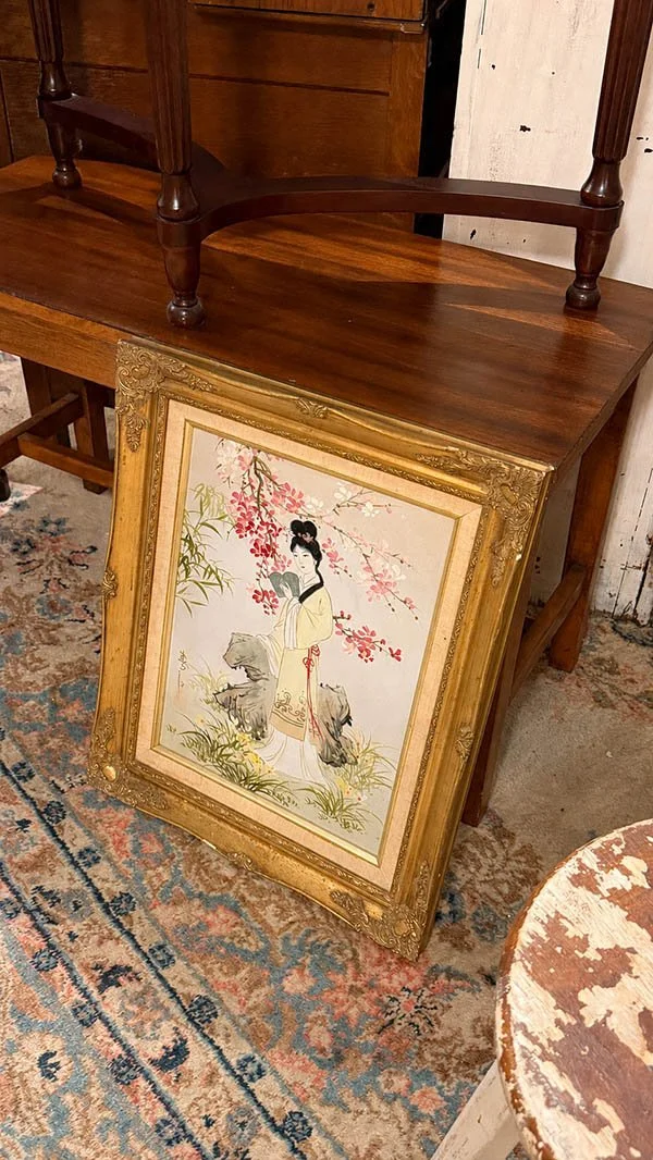 A gilt frame holding an image of a differing cultural and stylistic register