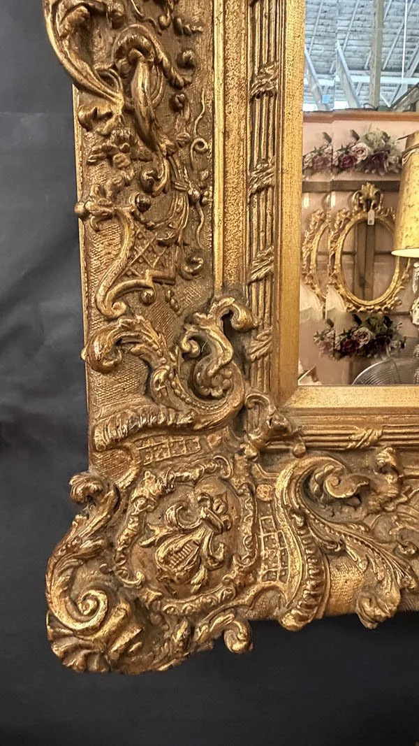 Macro detail of relief carving and gilt finish on an antique frame corner