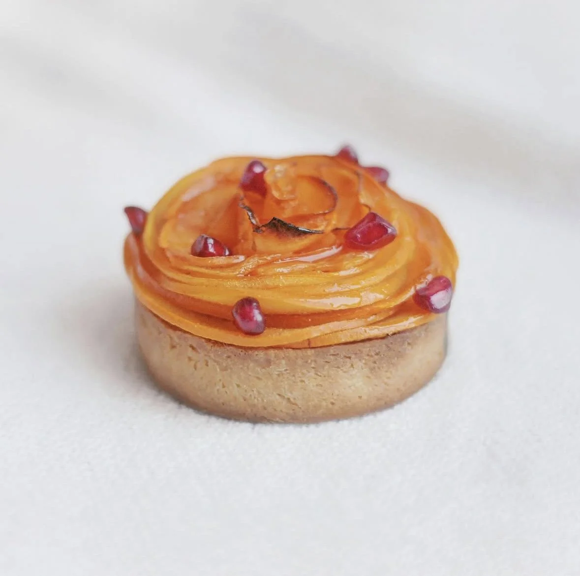 Tartelette au kaki garnie de graines de grenade.