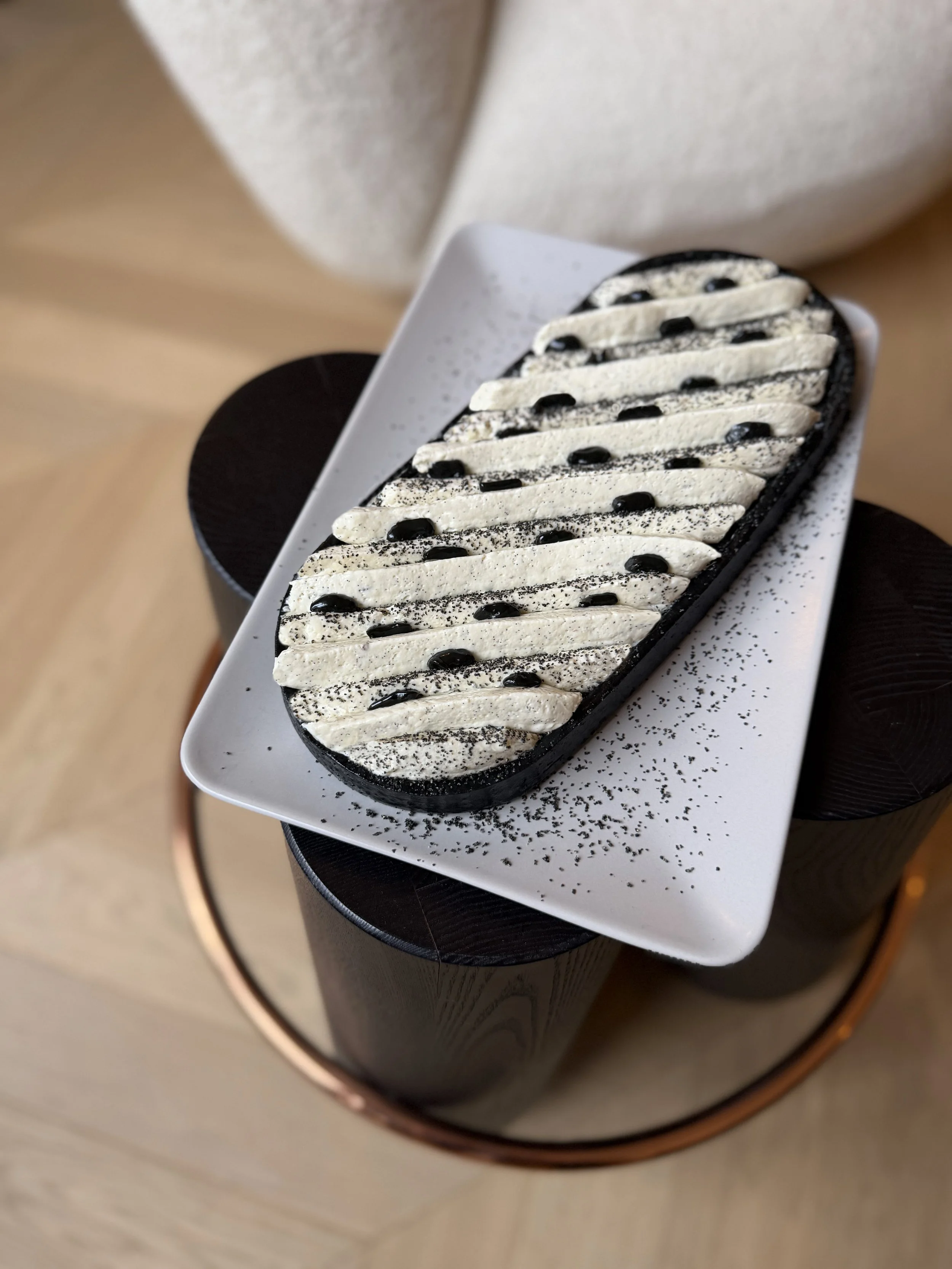Tarte vanille sésame noir décorée avec de la crème, des graines de sésame, du praliné sésame noir 