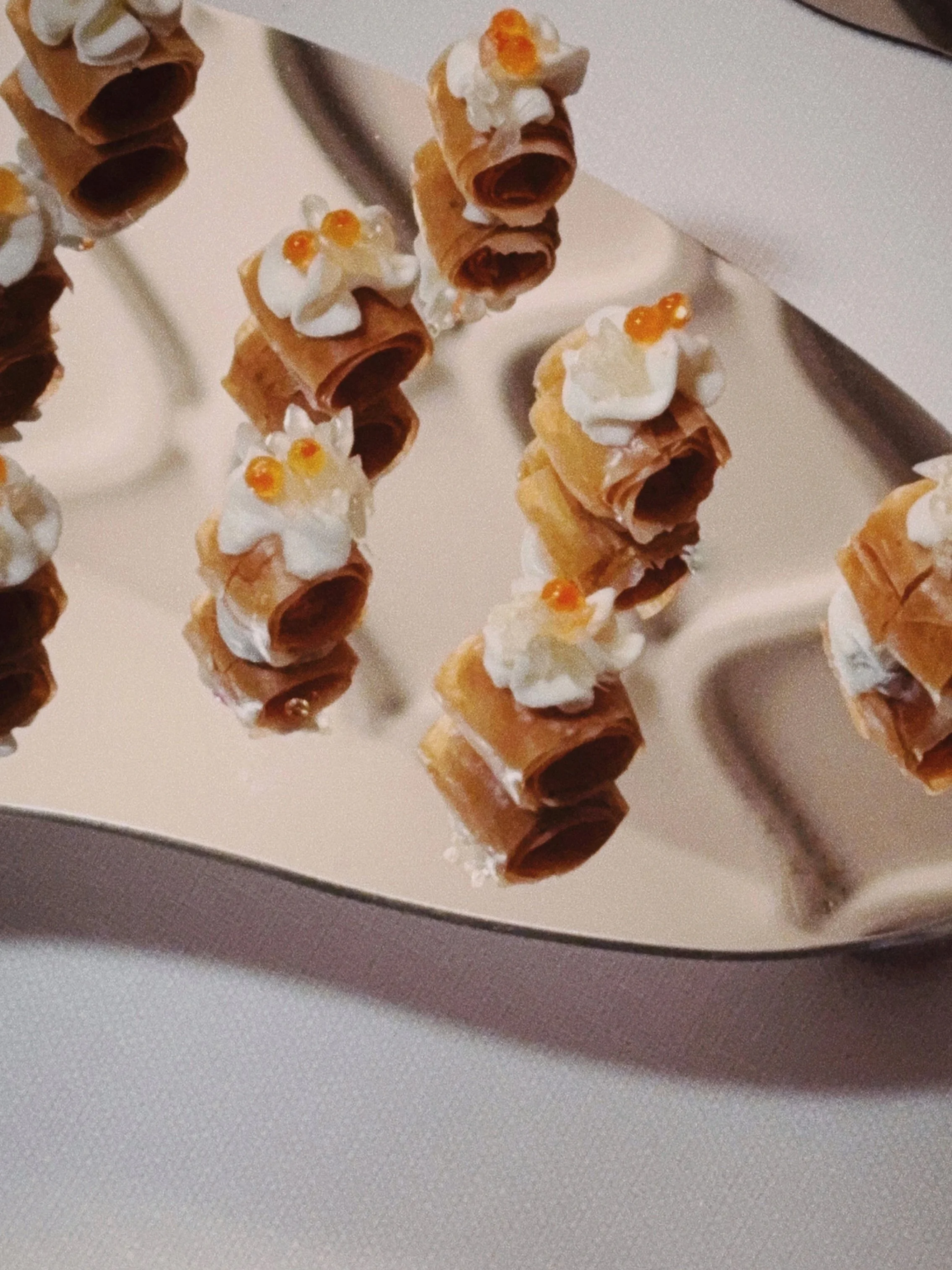 apéritifs enroulés de pâte feuilletée avec garniture de crème et de petites perles d'orange