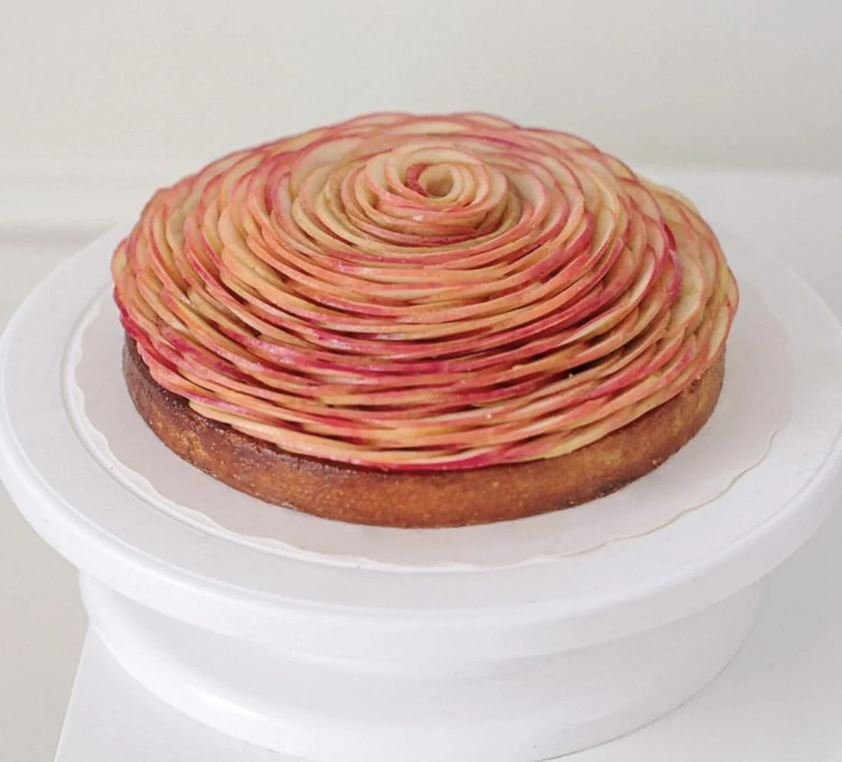 Tarte de forme ronde avec un décor en spirale de tranches de pommes. 
