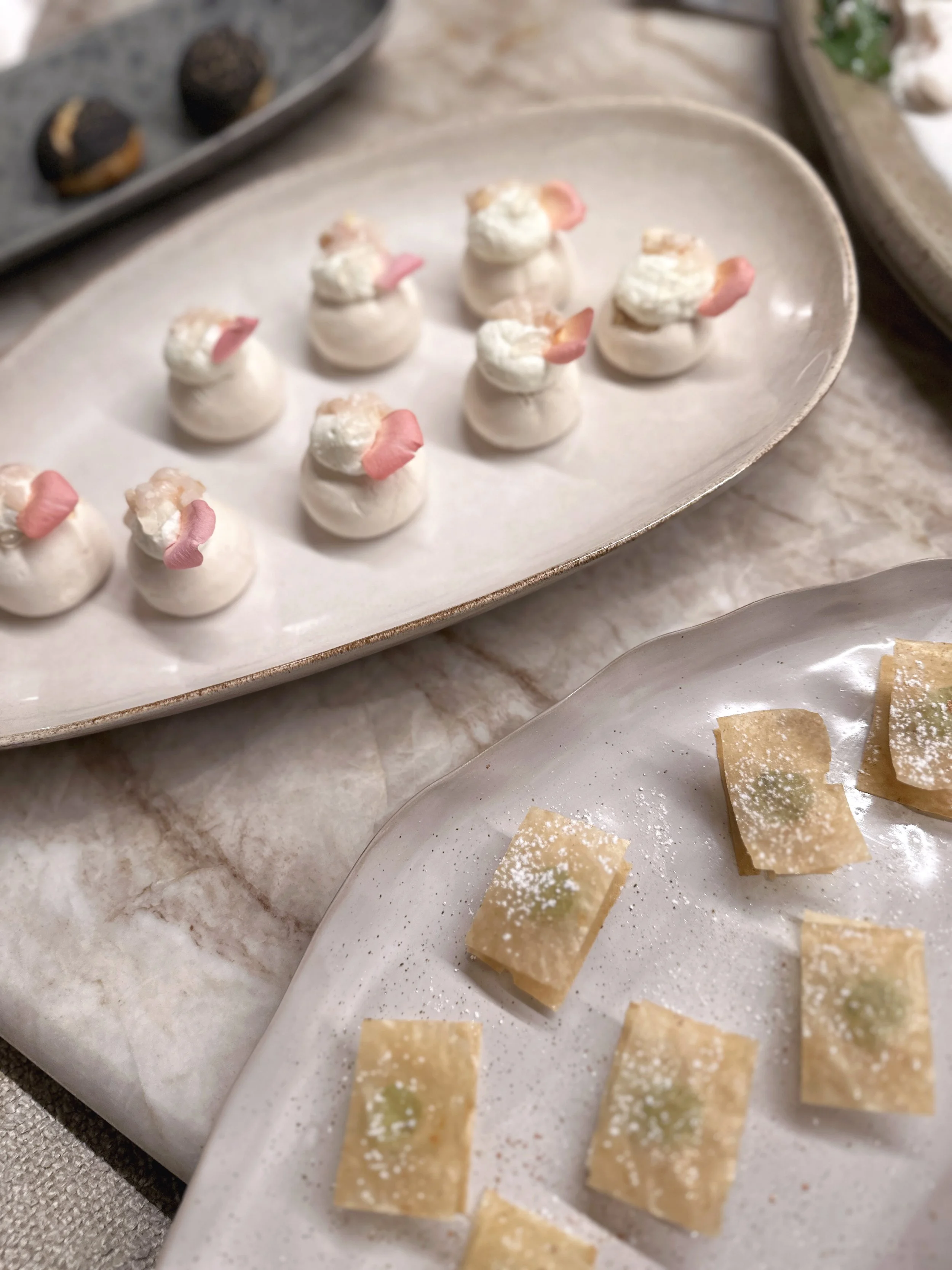 Gâteau de petites portions avec une jolie présentation, décoré de pétales roses et de crème.