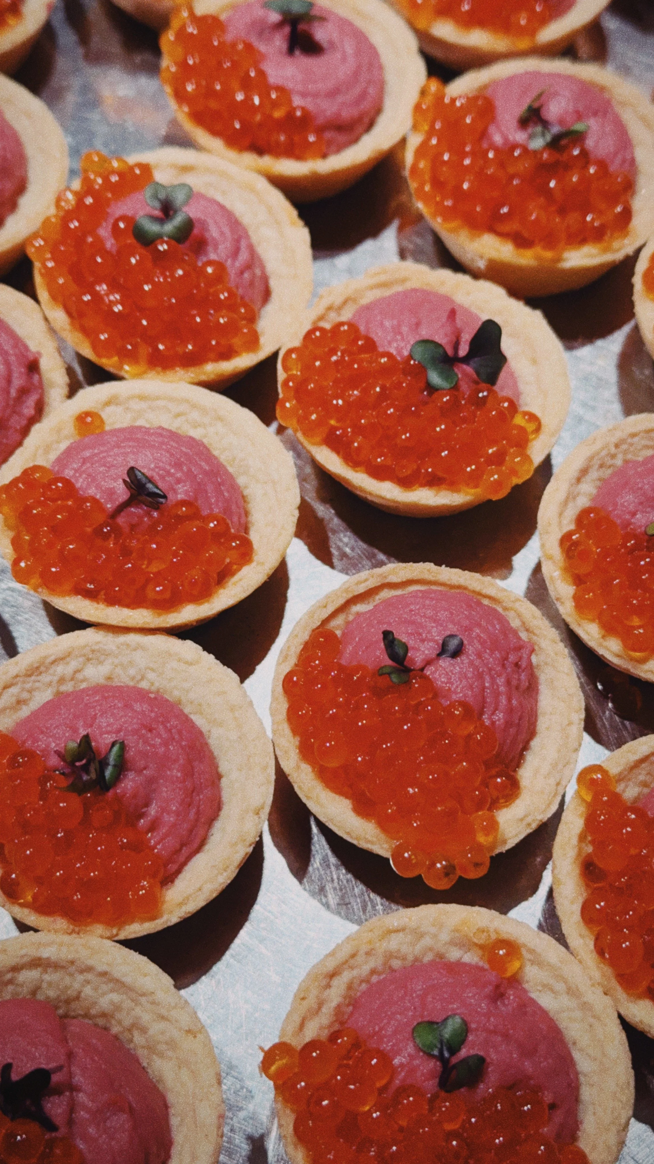 Petites tartes salées avec une base de pâte, garnies de jambon, de caviar d'algues et de microgreens.