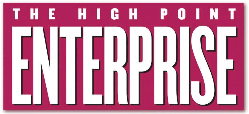 Pink and white sign with the words 'The High Point Enterprise' in large bold letters.