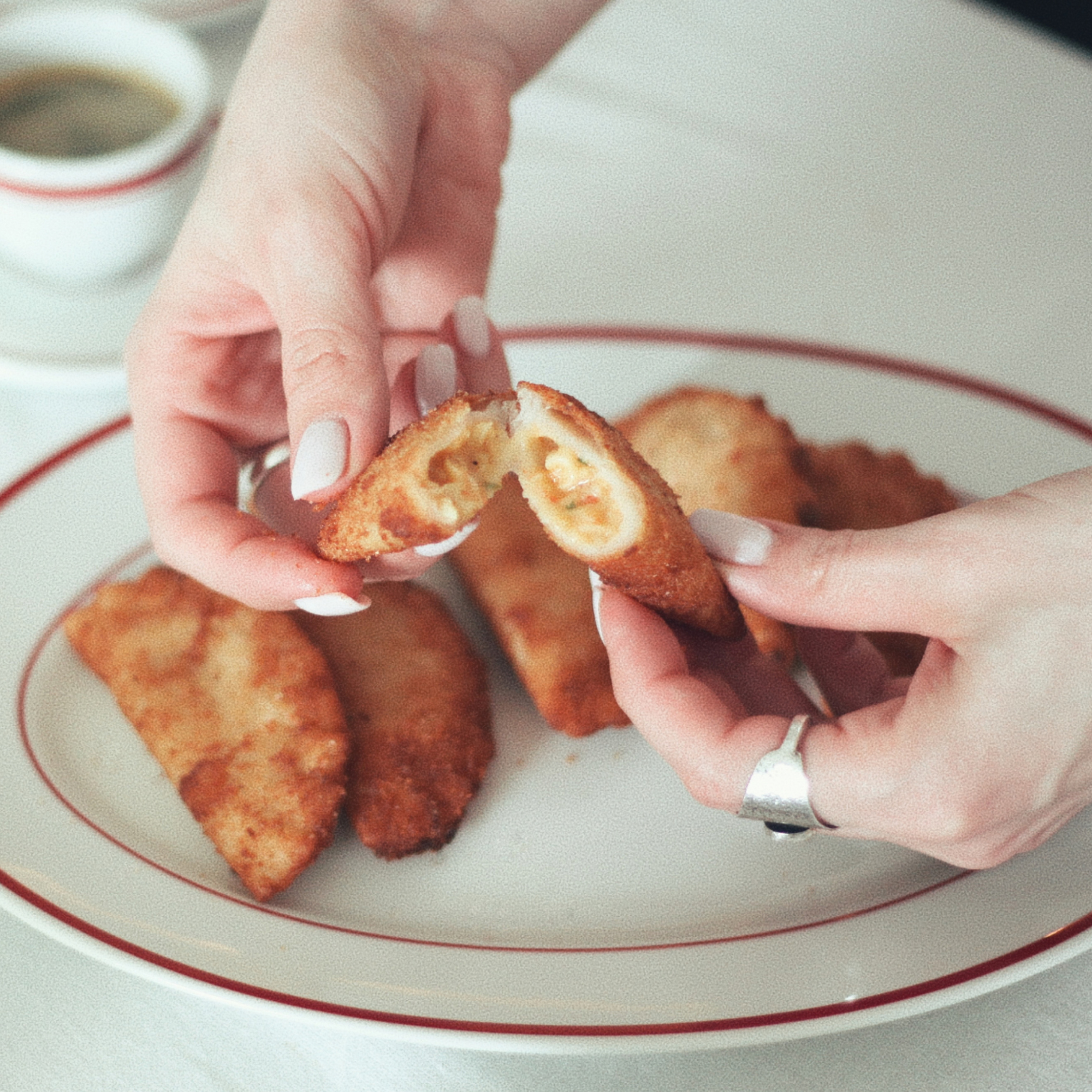 Handmade Portuguese shrimp rissois broken open to reveal a creamy shrimp filling, served golden and crispy.