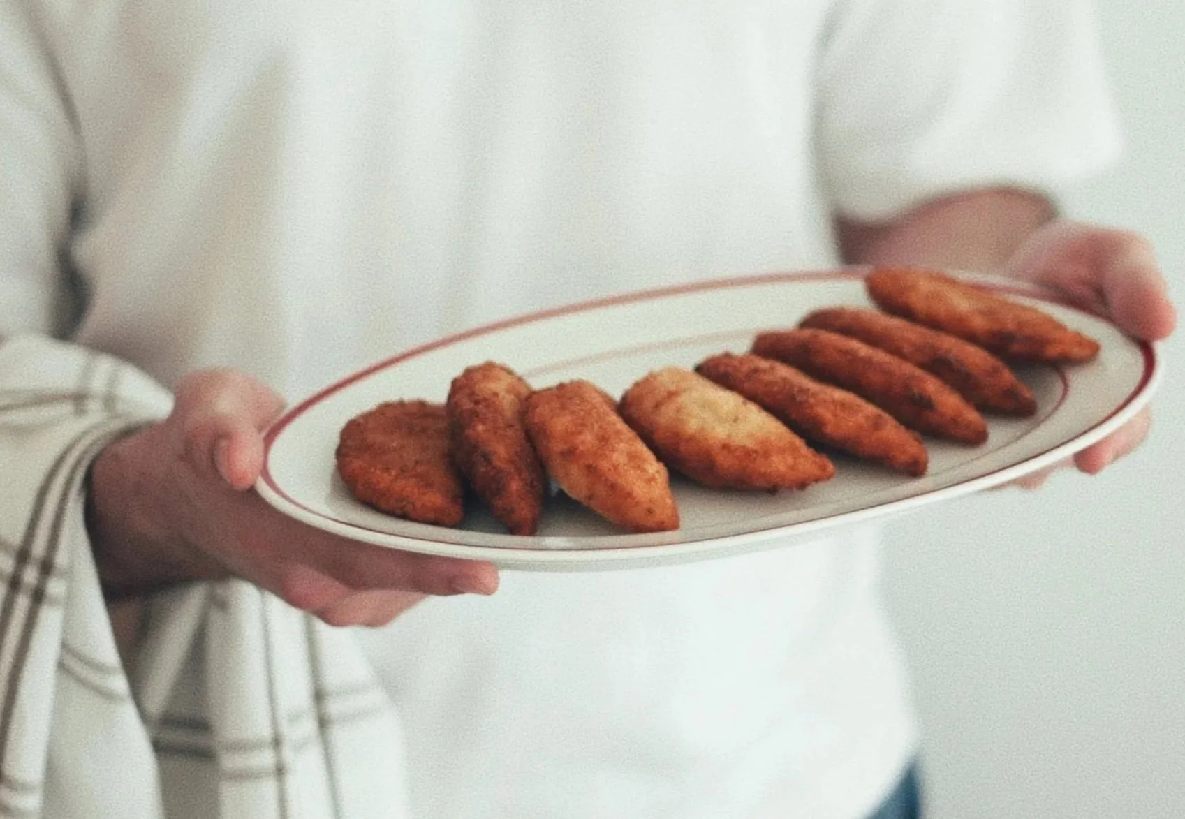 A platter of golden, handmade Portuguese rissois being served, inspired by a traditional family recipe.