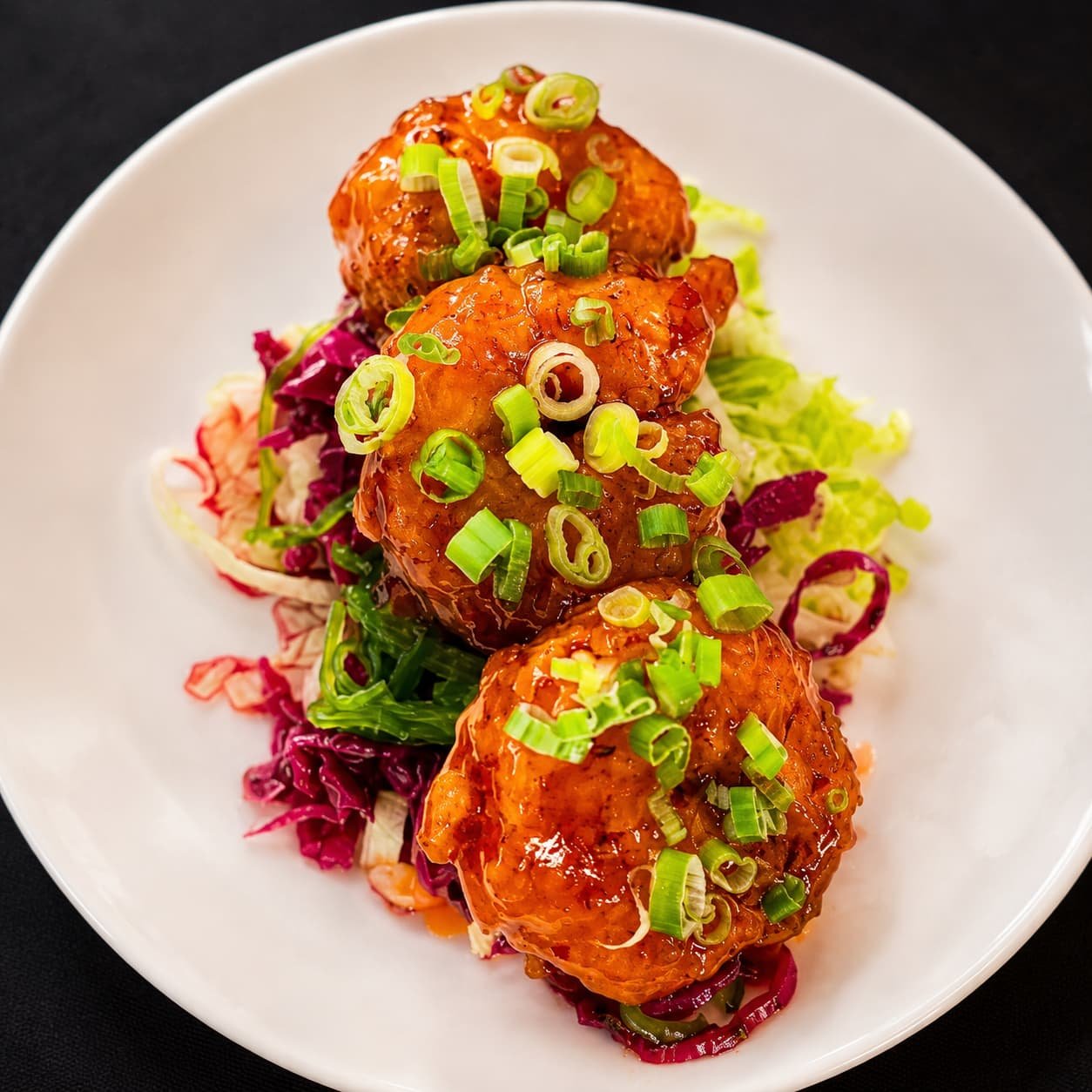 Fire cracker shrimp battered and flash fried in hot and honey butter sauce served on Asian braised slaw at Leelanau Steakhouse Seafood & Pasta