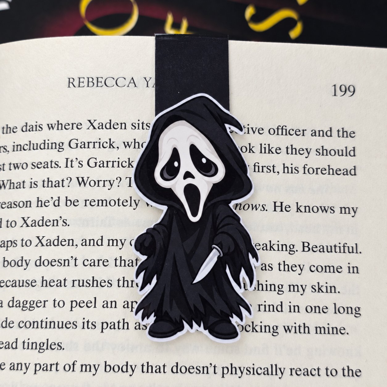 Double-sided magnetic bookmark featuring a cartoon Ghostface in a black hooded robe holding a knife, with a black tab.