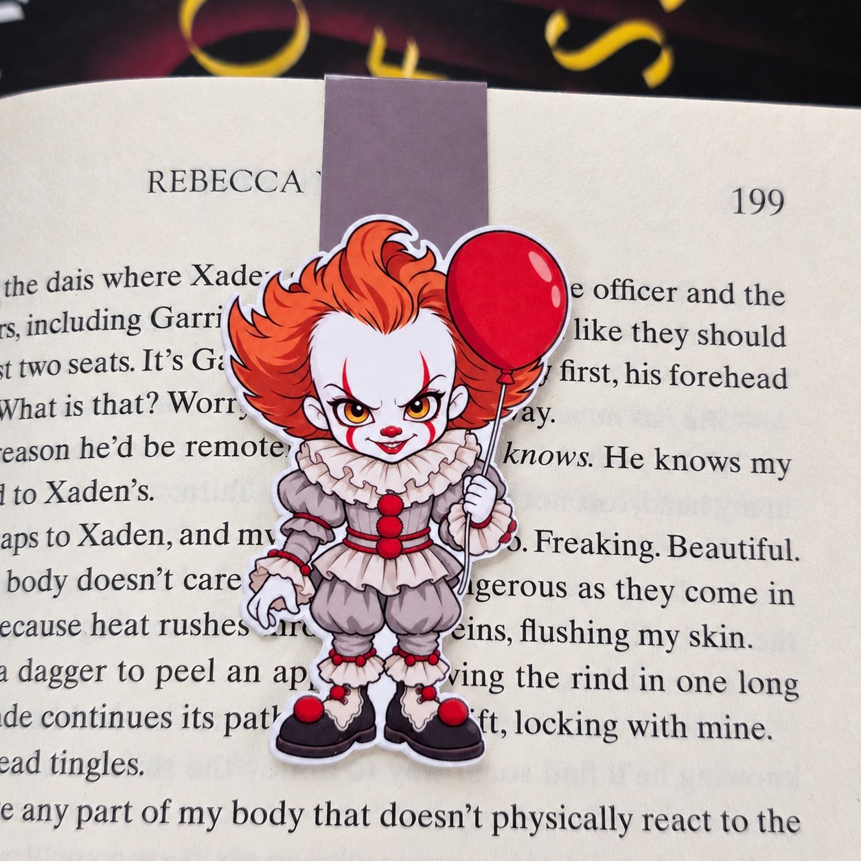 Double-sided magnetic bookmark featuring a cartoon Pennywise with orange hair, a ruffled clown costume, and a red balloon.