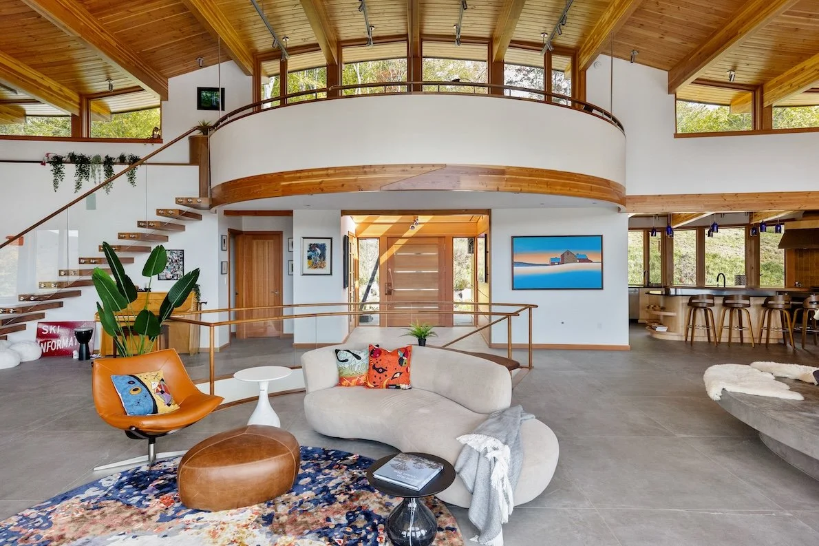Great room in a custom home in Wilmington, Vermont, with curved interior walls, wood ceilings, and an open plan shaped around the home’s circular form.
