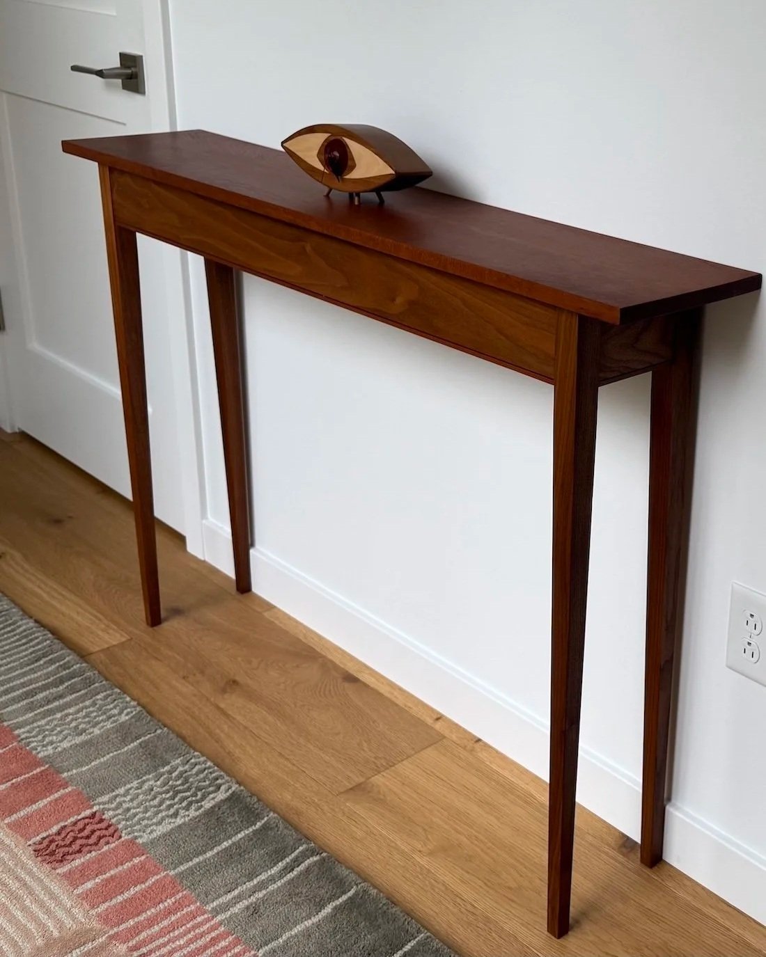 Custom walnut console table with tapered legs by Red Mountain Construction in Vermont