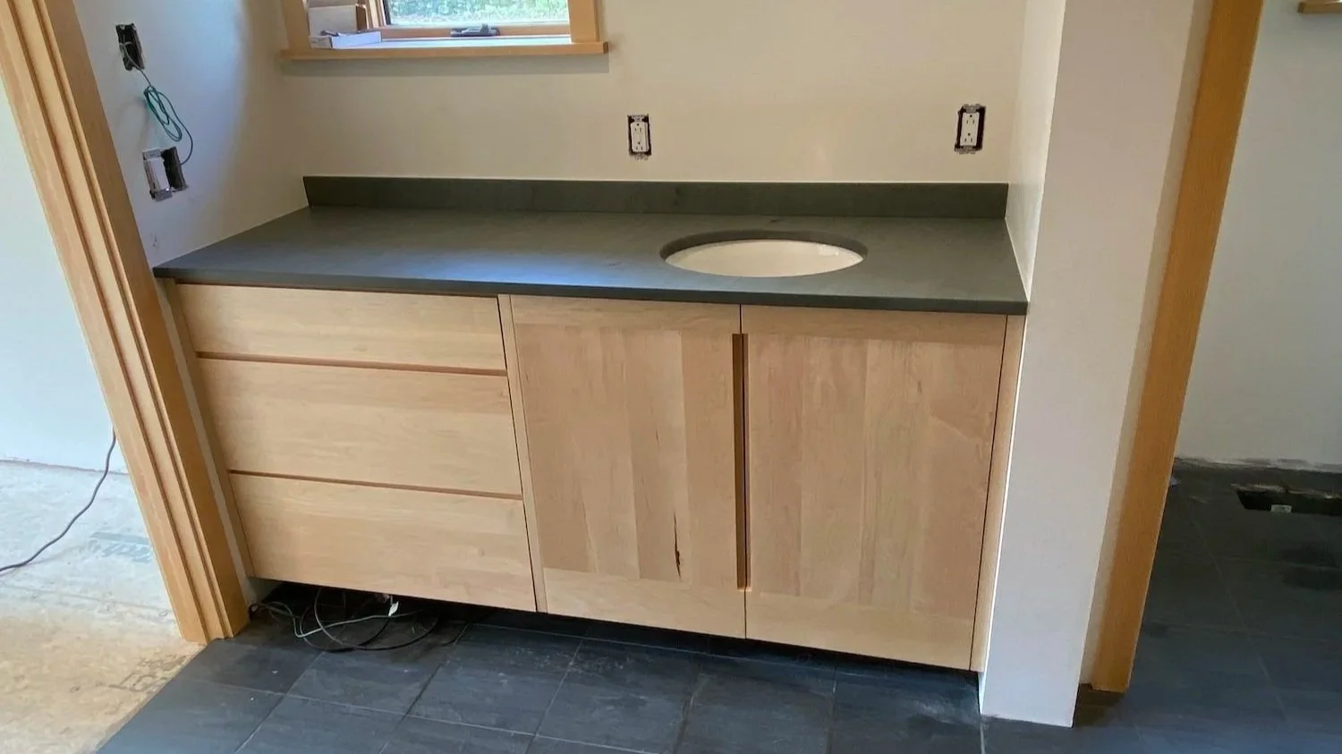 Custom wood bathroom vanity and tile flooring by Red Mountain Construction in Vermont