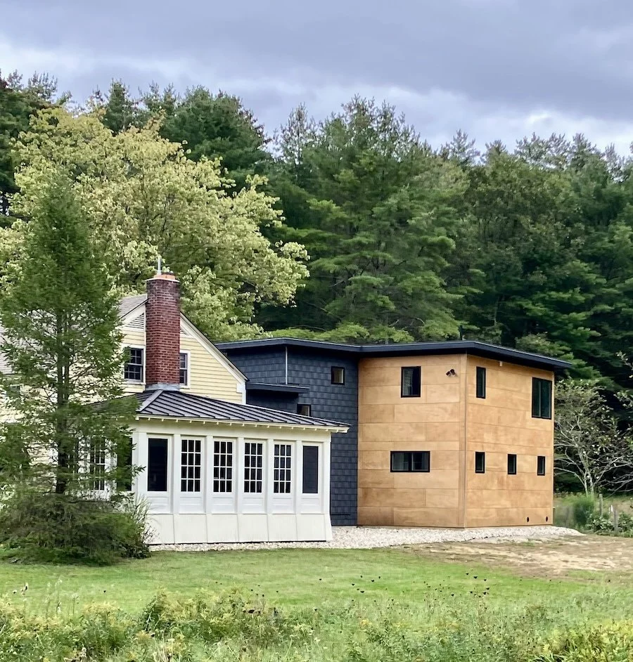 Rear exterior of renovated cape-style home with modern mid-century addition in Arlington, Vermont