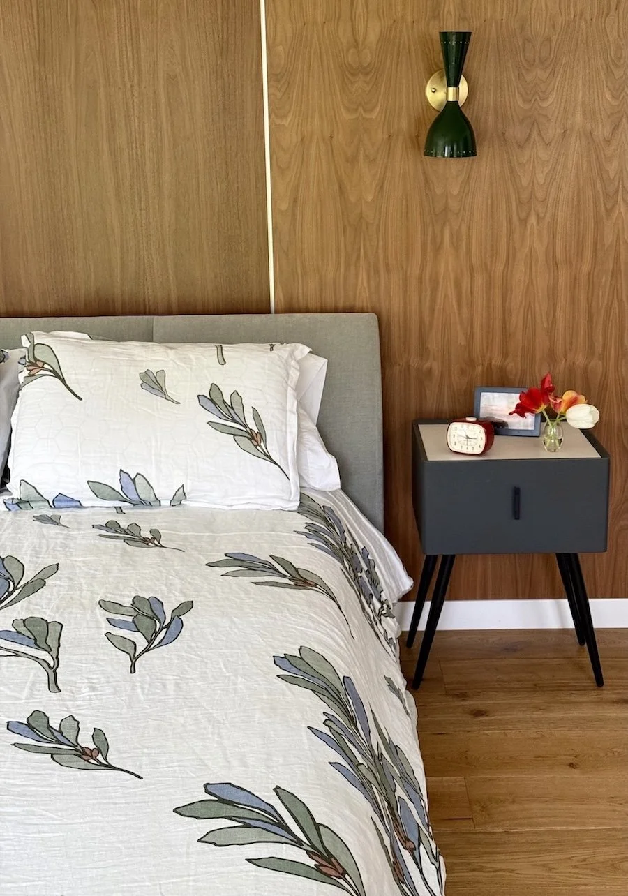 Custom bedroom with wood accent wall and custom light fixture in mid-century modern home addition in Arlington, Vermont