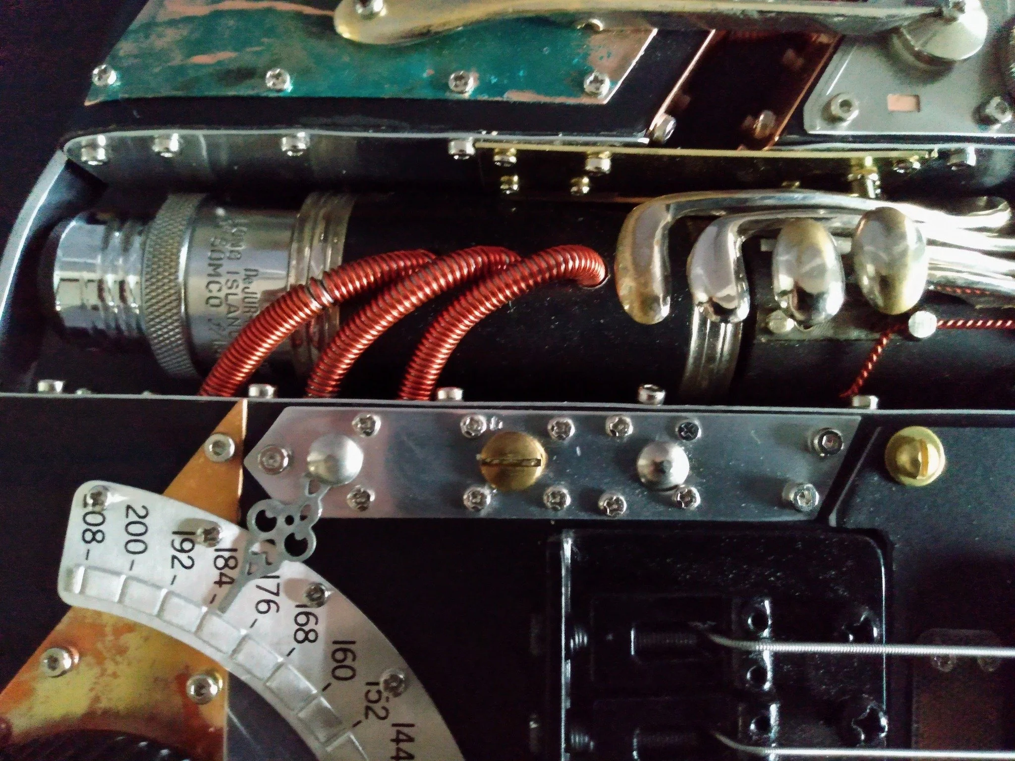 close up detail of Steampunk Guitar, made by Mike Moulton, luthier at Immortal Guitars. using clarinet parts, copper tubing, guages, labels, one of a kind