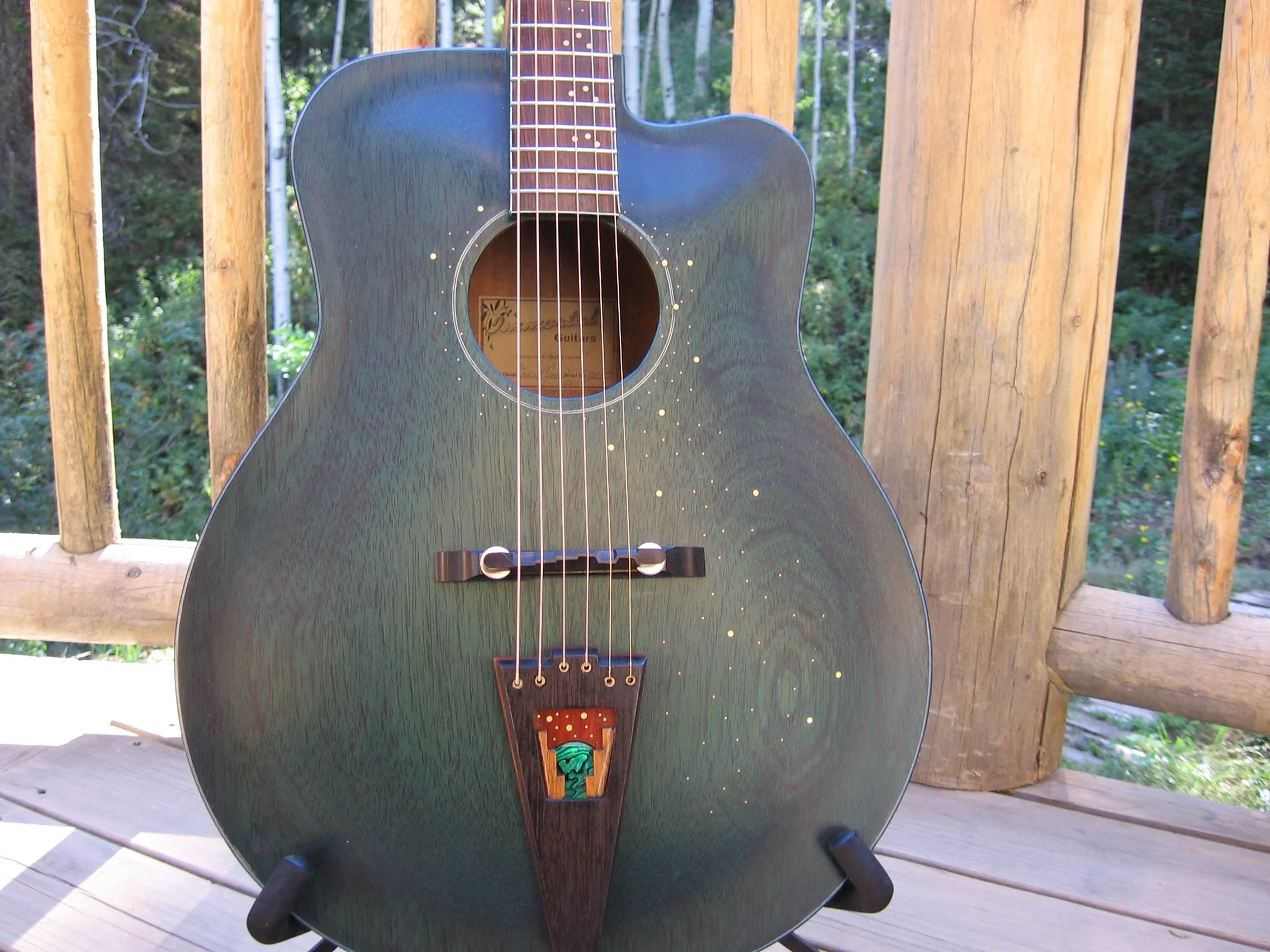 hand carved archtop by Elaine Moulton, Immortal Guitars. Mahogany top, back, sides. Tailpiece with inlay of moon, stars, mountains. Brass stars inlay on front of guitar.