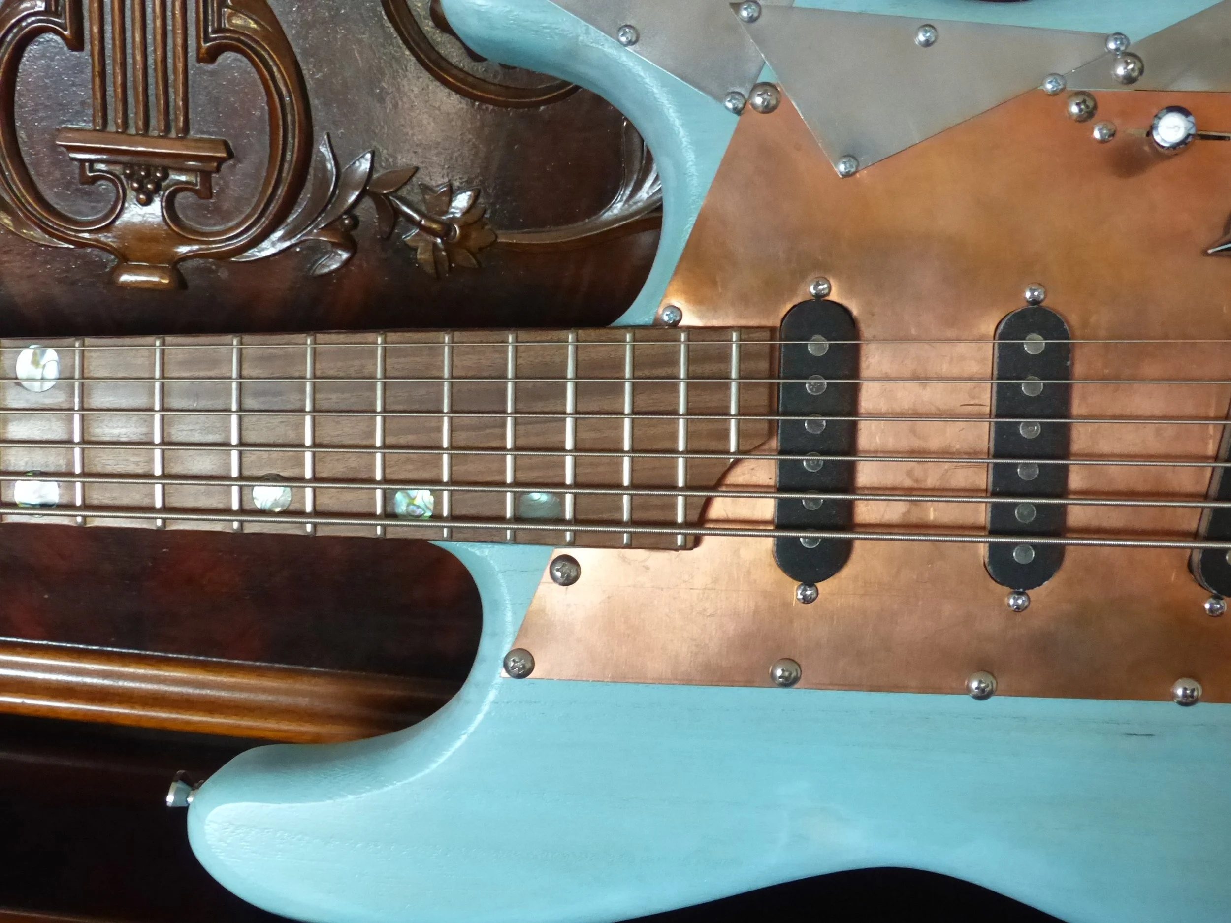 6 string bass, custom made by Mike Moulton at Immortal Guitars, copper pickguard, inlay party theme of mother of pearl and abolone, lightweight, rosewood fretboard.