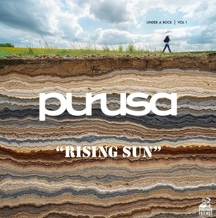 Book cover for 'purusa: Rising Sun' with layered rock formations and a person walking with an umbrella on top, sky with clouds in the background, and text indicating volume 1 of 'Under a Rock' series.