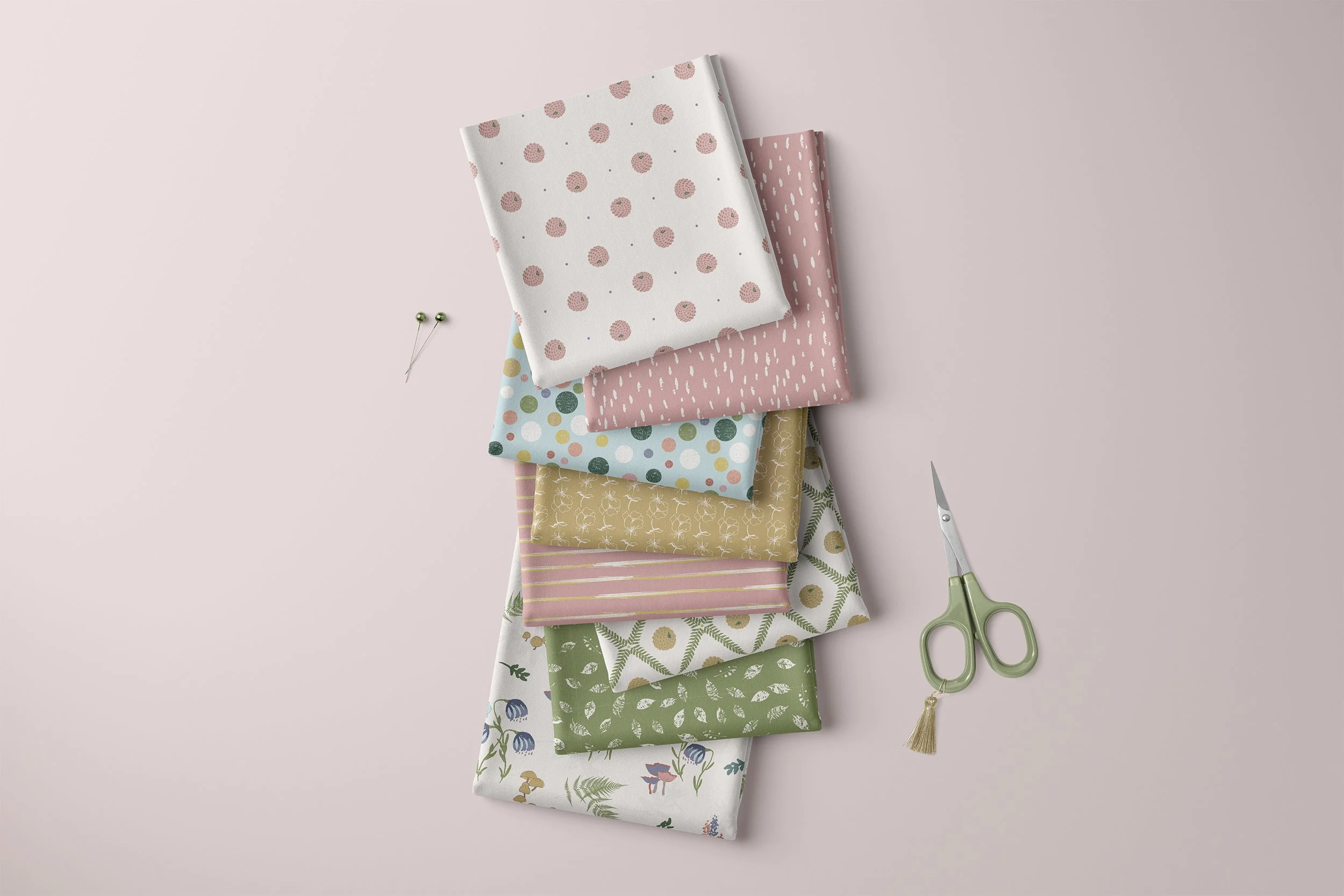 Whispering Wilds Morning Light surface pattern collection shown on a stack of coordinating fabrics.