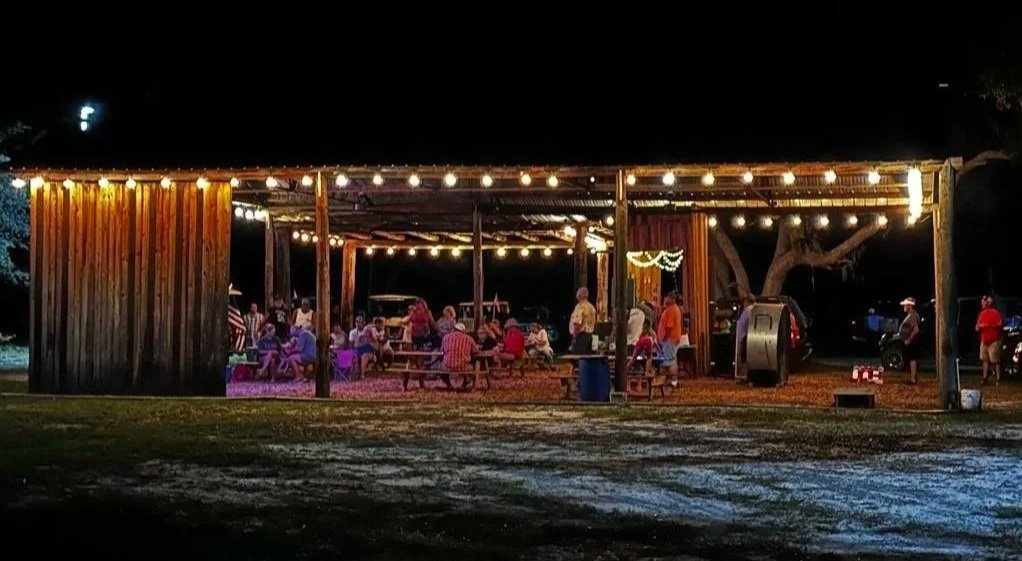 The event pavilion at night lit up with a crowd. 