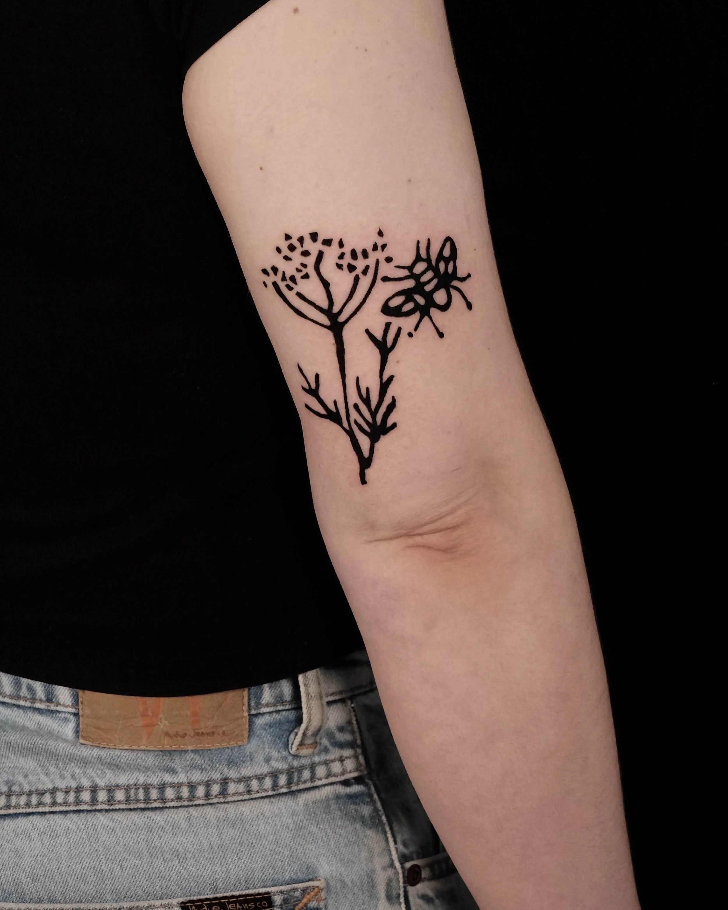 Bold lin-print inspired botanical tattoo on the arm by Pip