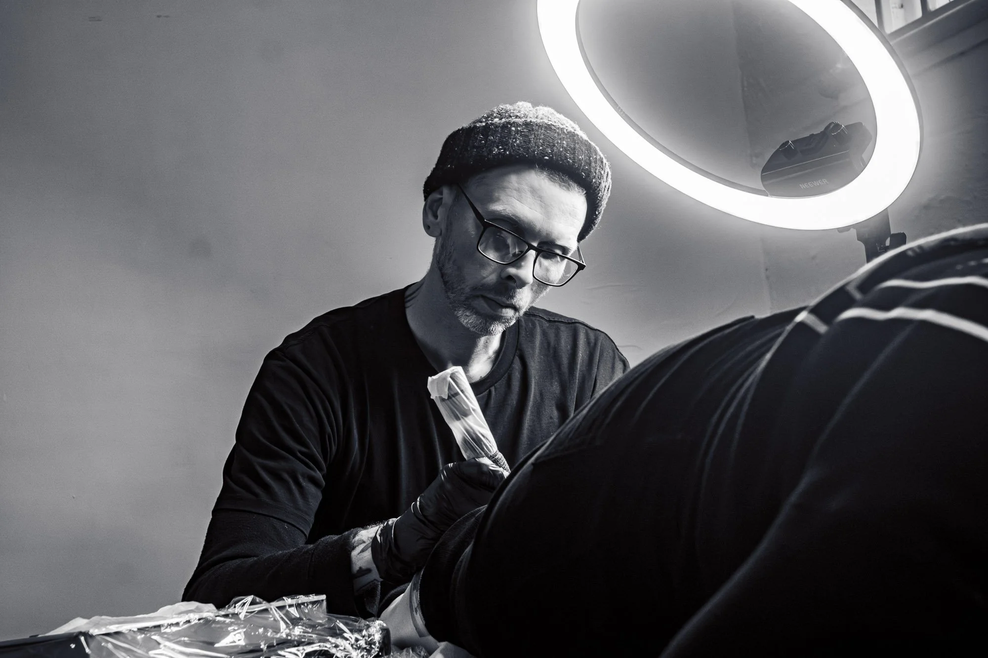 Jak tattooing clients calf in Together Tattoo studio