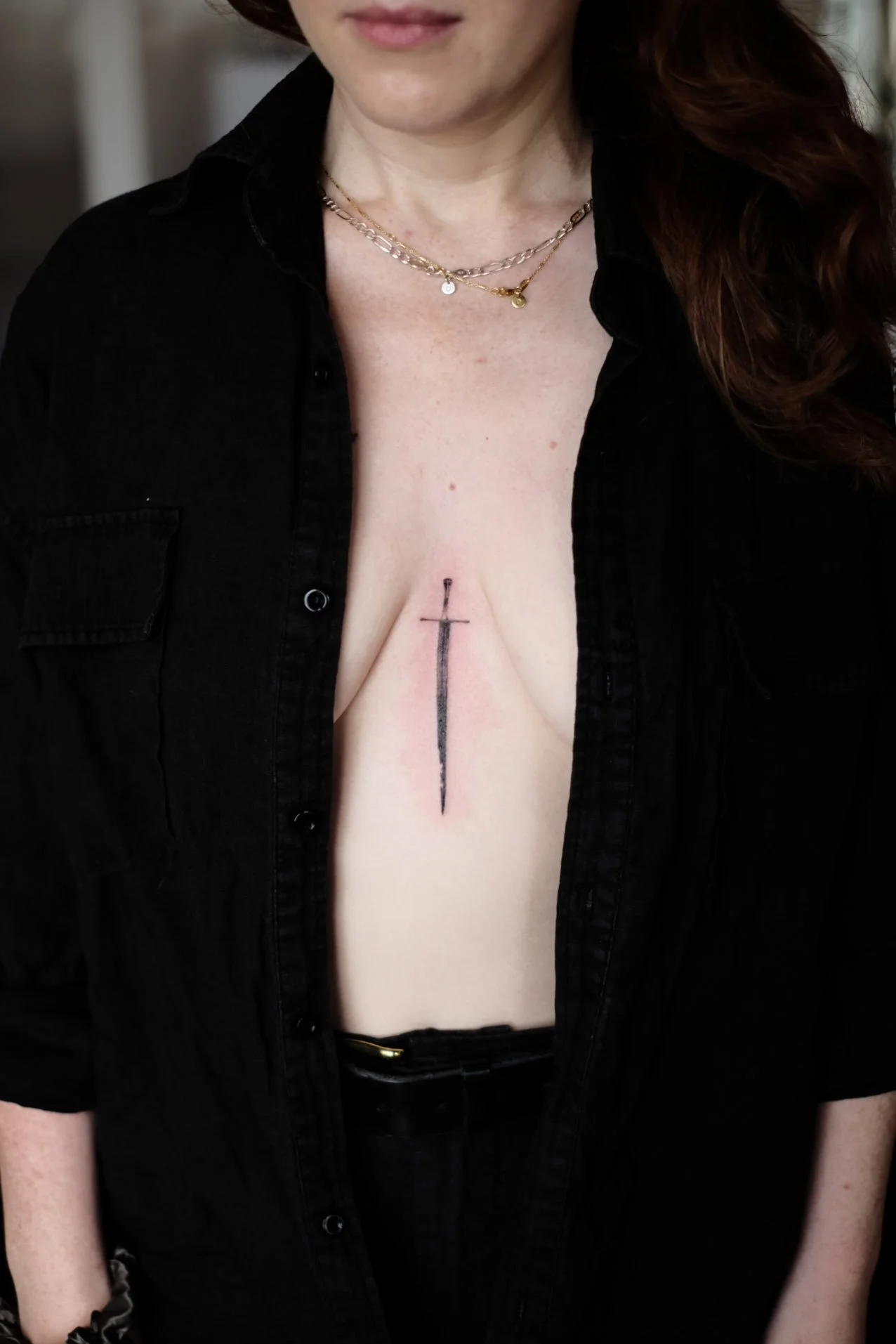 Micro fine line tattoo of a sword on the chest by Jak