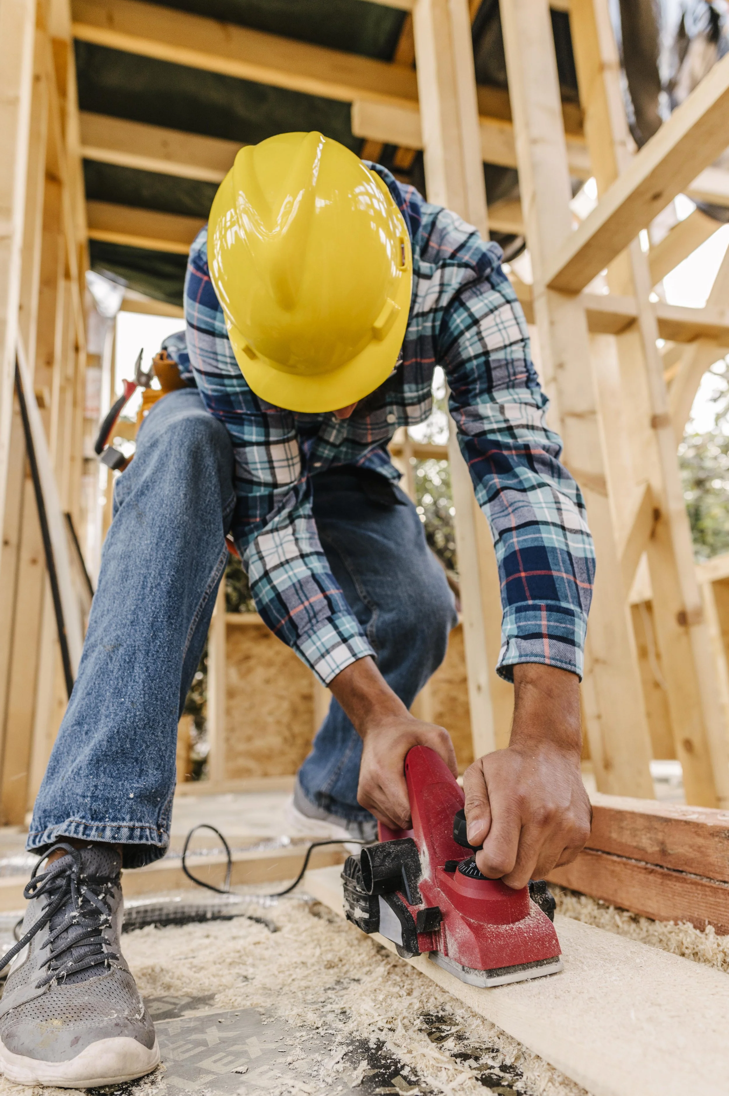 construction-worker-with-hard-hat-sanding-down-wood-piece.jpg