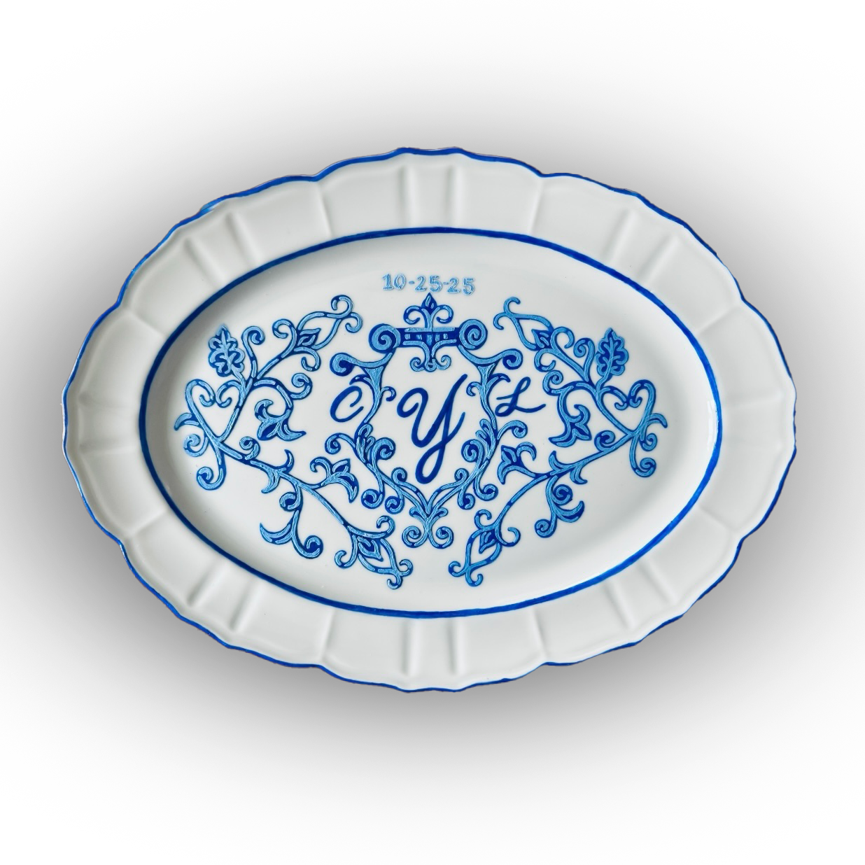 custom white oval ceramic dish with blue decorative pattern and monogram 'Y' in the center, and the date '10-25-25' above, with a scalloped edge.