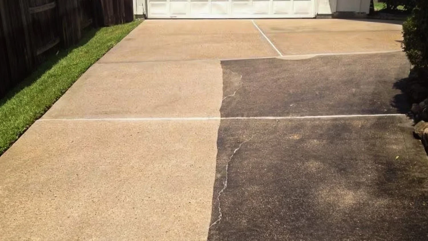 A driveway with concrete on the left and asphalt on the right, showing a clear line of transition between the two surfaces.