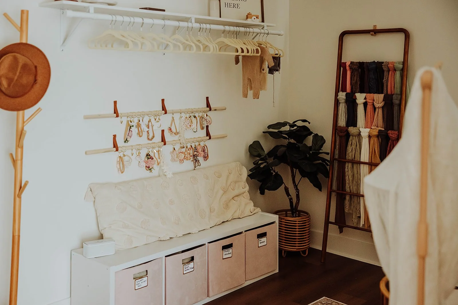 Prop and wardrobe corner with hanging outfits, headbands, storage bench and blanket ladder at The ANS Collective studio