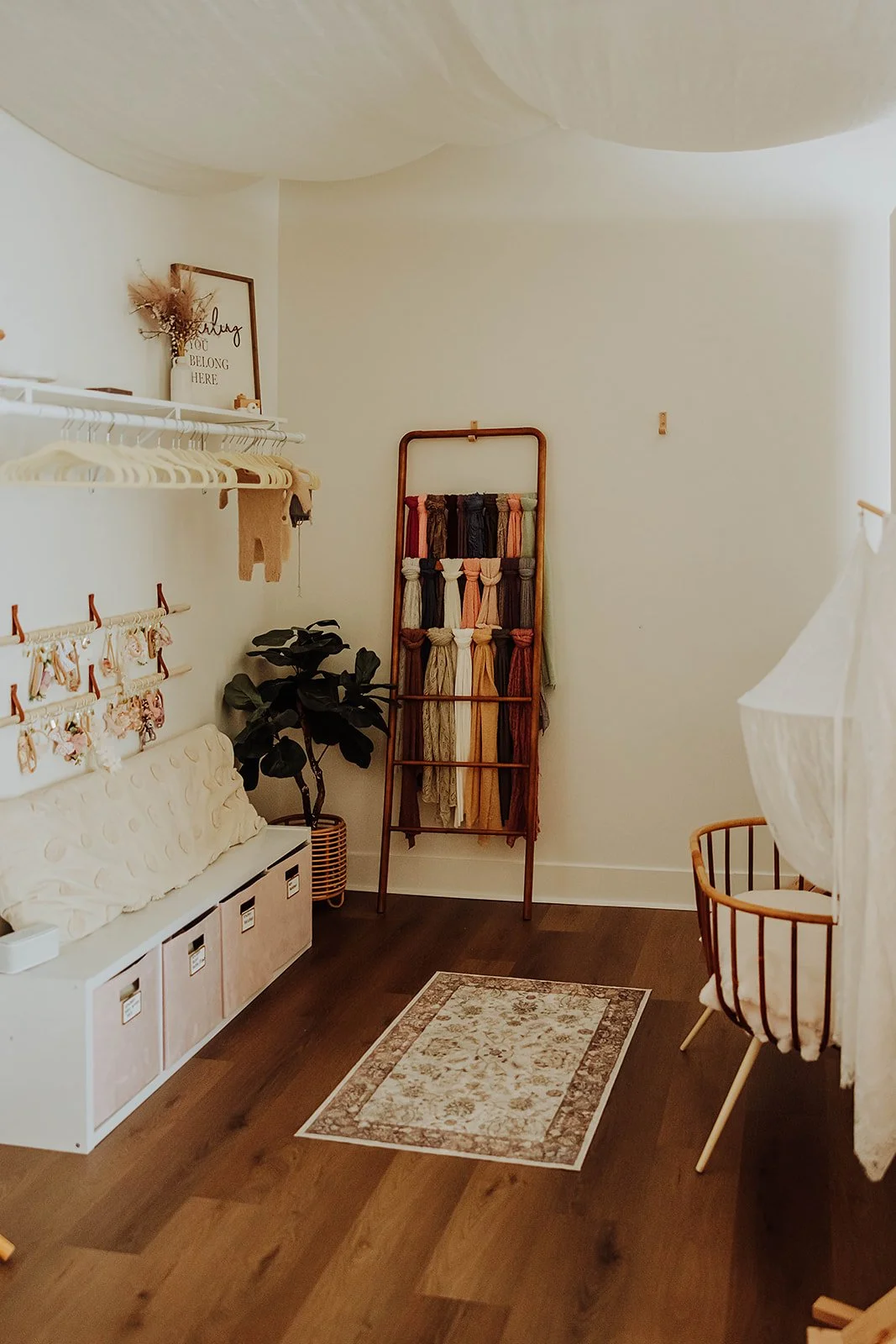 Inside The ANS Collective photo studio in Grandville, MI, with wardrobe rack, storage bench and wood floors