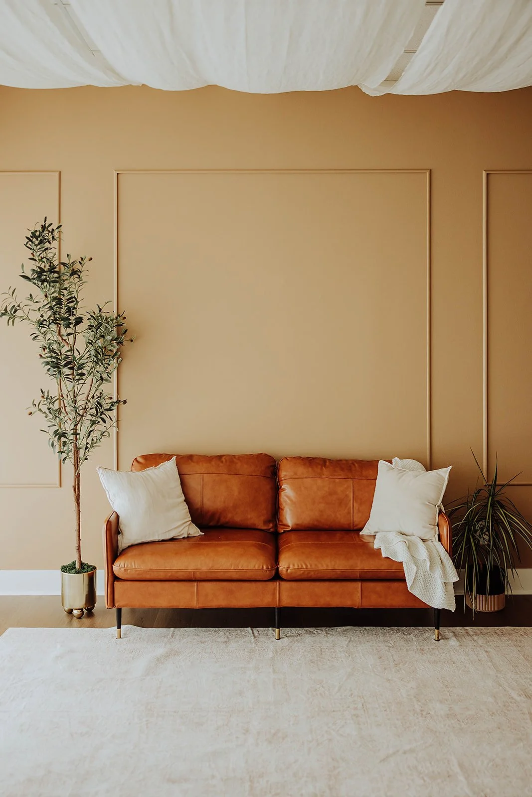 Leather sofa set with a cream rug in The ANS Collective natural-light photo studio in Grandville, MI