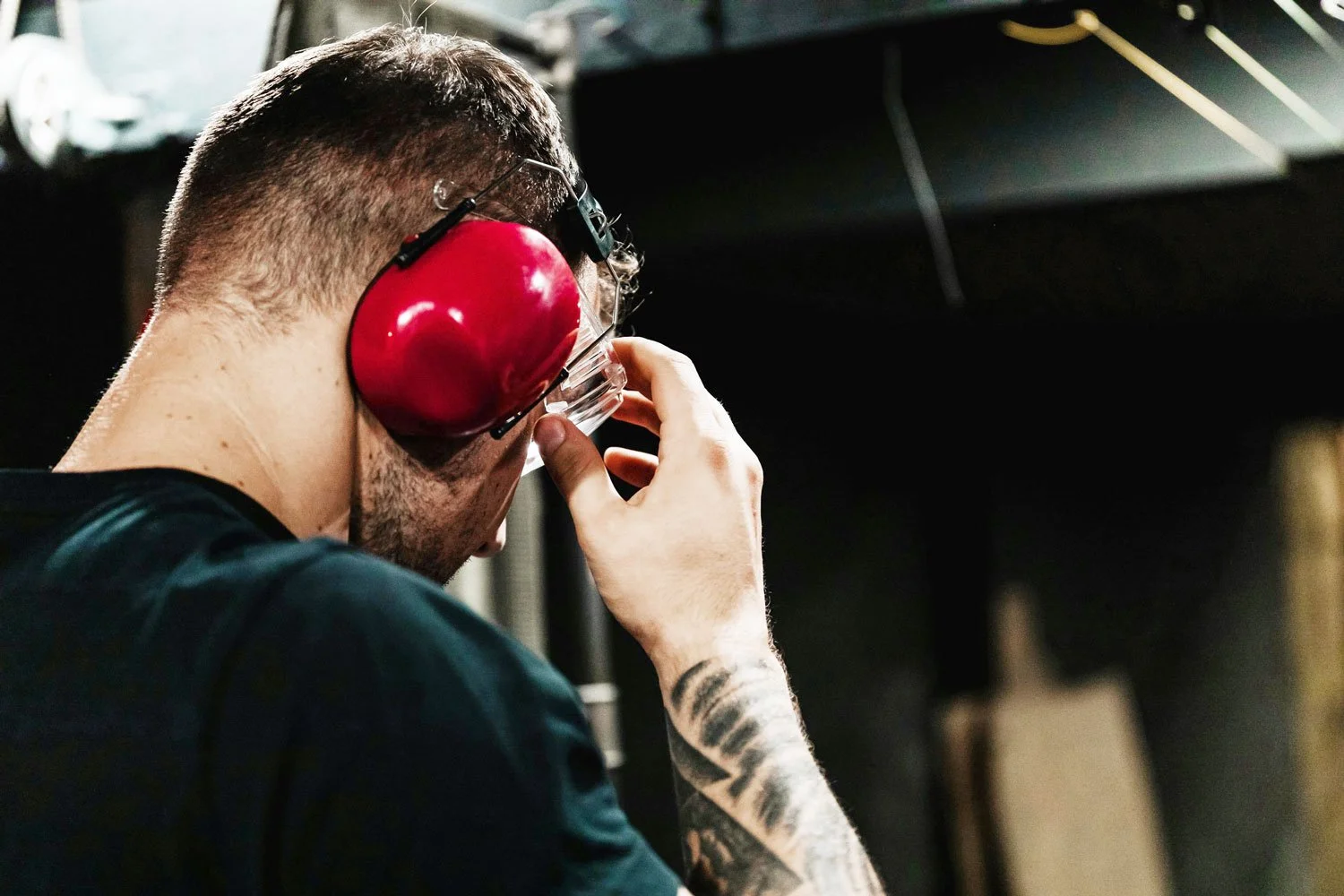 man wearing protective hearing earmuffs and safety glasses for workplace noise monitoring