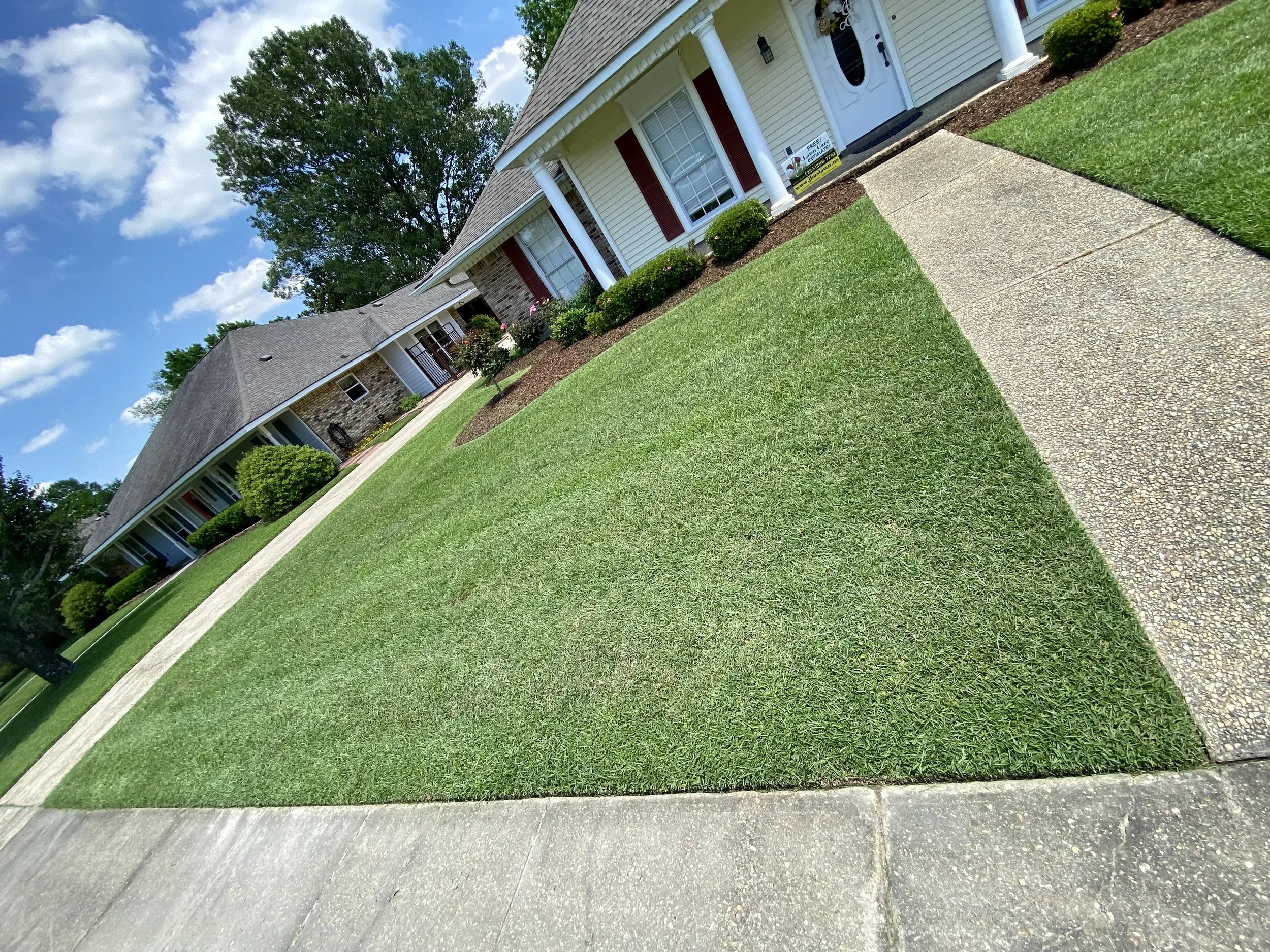 Freshly maintained front lawn with clean edging and trimmed flower beds at a residential property.