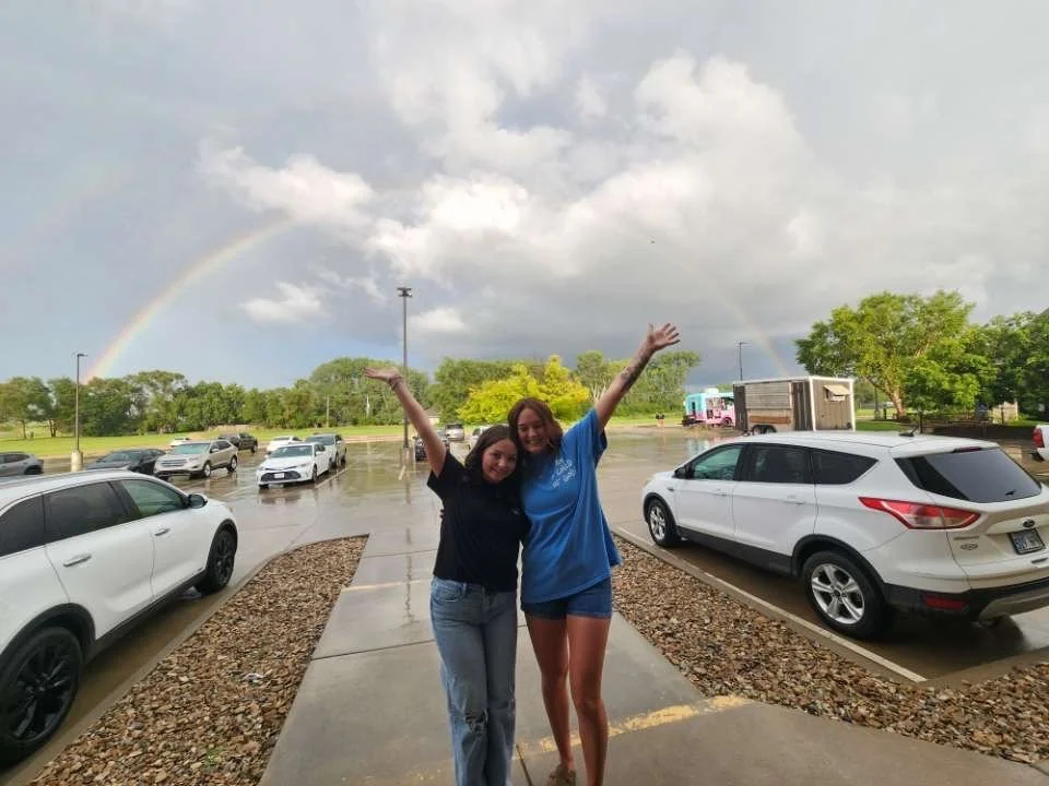 An image of Reagan and Abby under rainbow