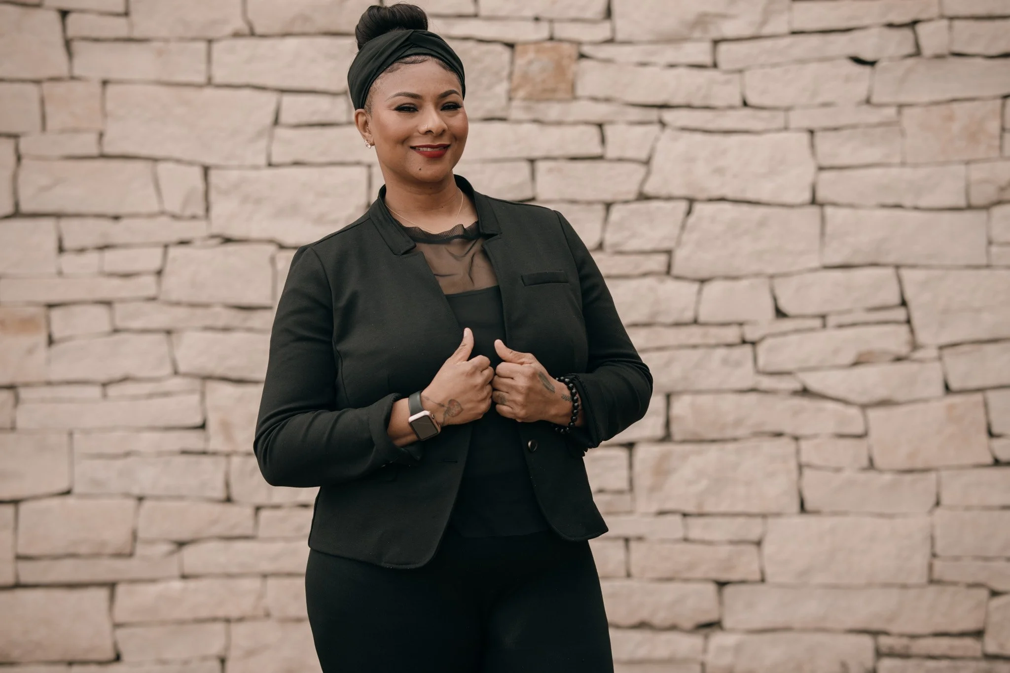 A portrait image of Jessica standing in front of stone wall