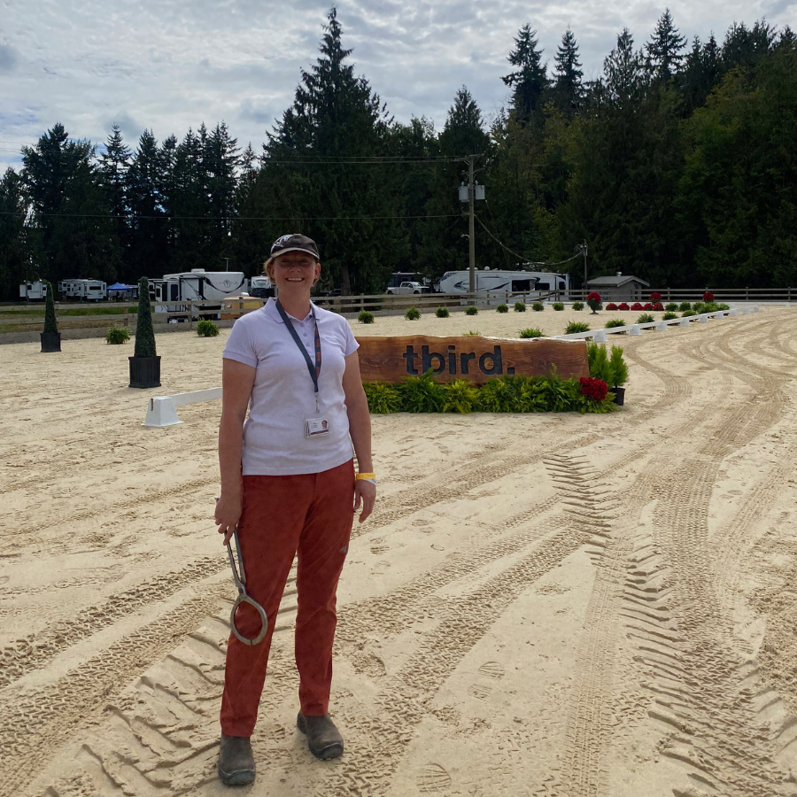 A veterinarian standing in a sandy arena at Thunderbird Show Park.