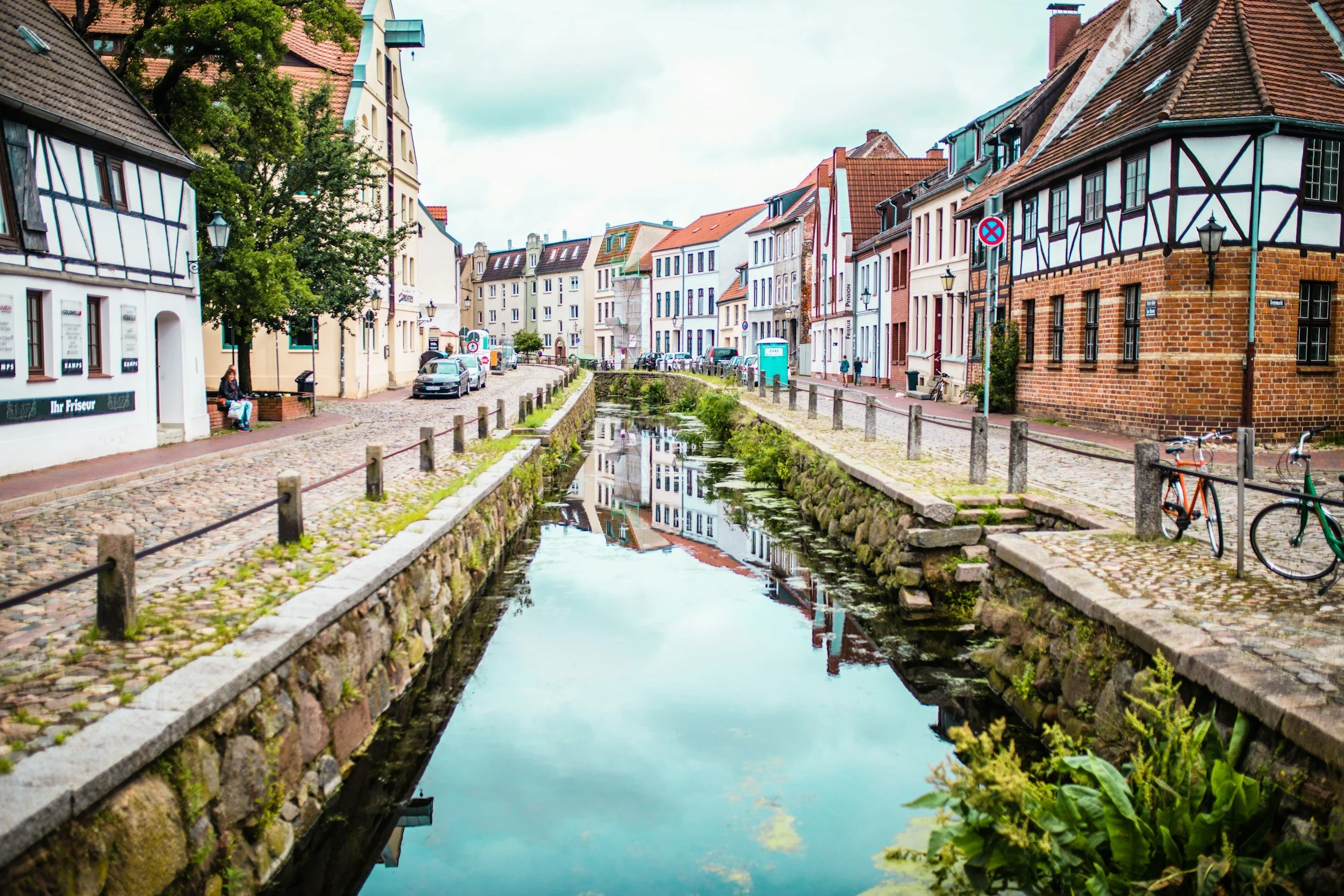 Colorful historic houses along the medieval Grube canal in the UNESCO old town of Wismar, Germany; an authentic Hanseatic discovery curated by Willow & Wander Travel.