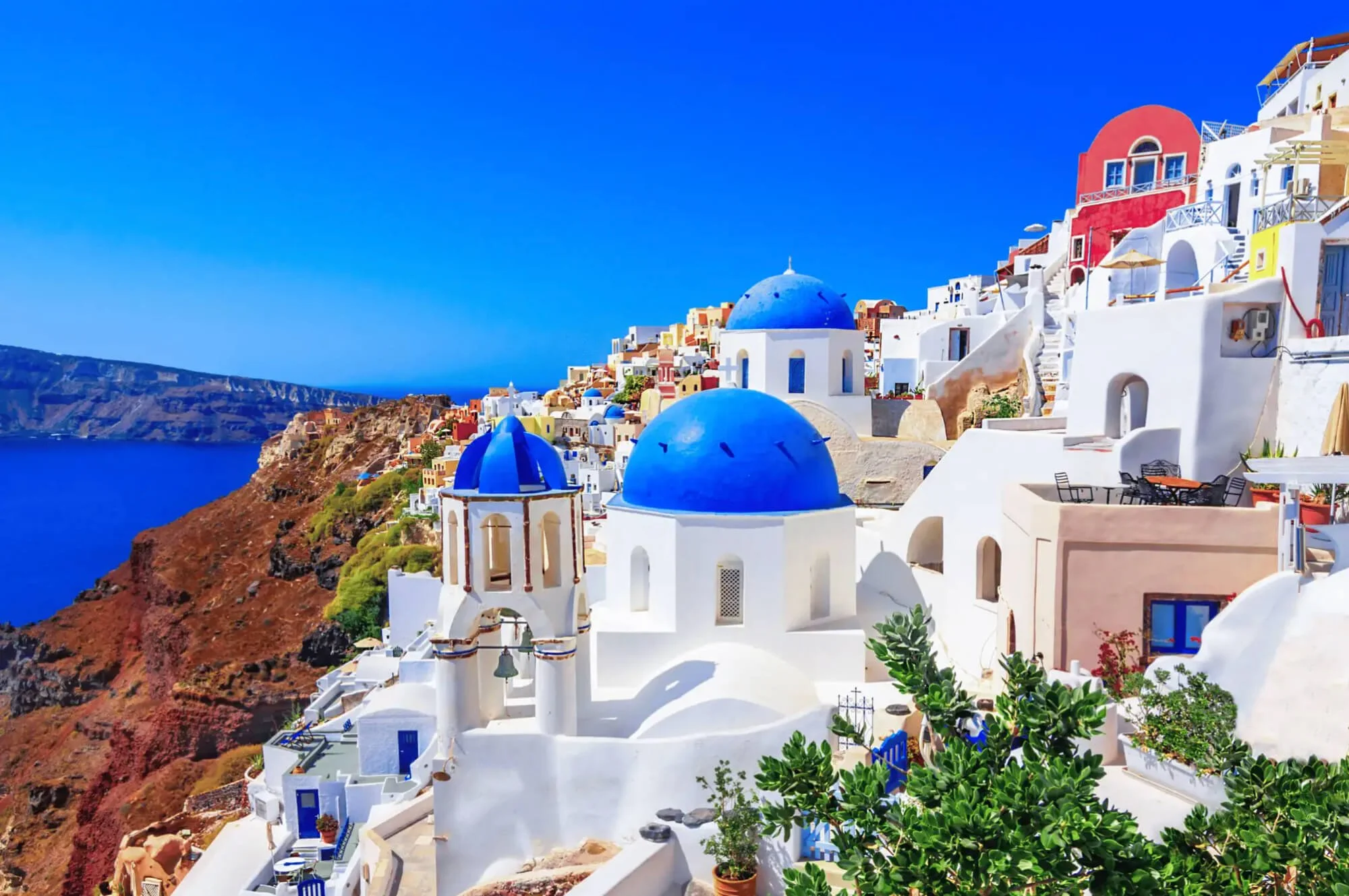 The iconic blue domes and white-washed architecture of Oia, Santorini; a signature Mediterranean ocean port discovery curated by Willow & Wander Travel.
