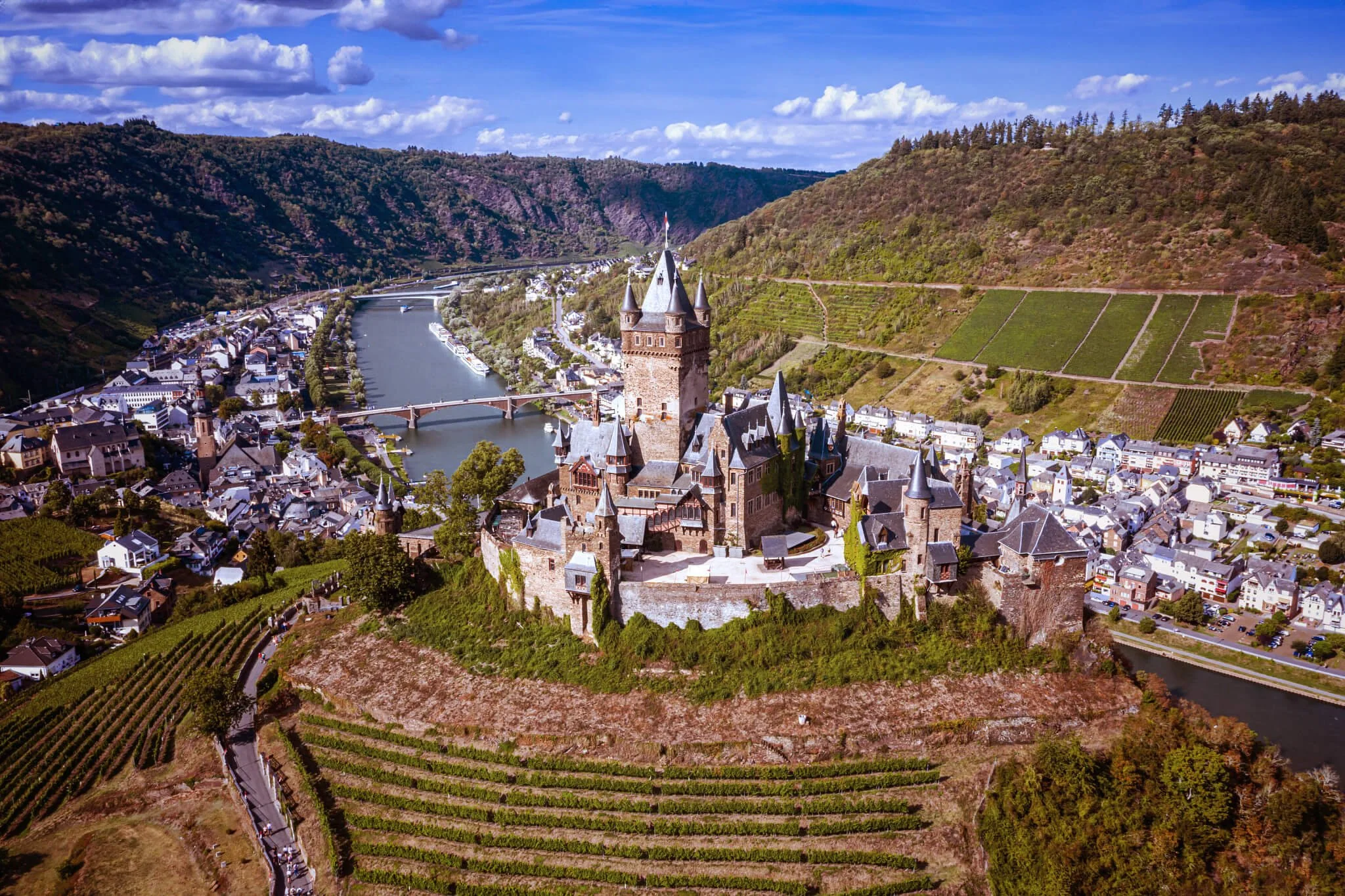 An aerial view of the Rhine and Moselle river valleys with historic castles and terraced vineyards; a boutique river discovery curated by Willow & Wander Travel.