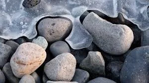 Smooth river rocks surrounded by ice.