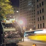 Nighttime in the city. A garbage truck makes its rounds.