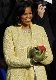 Michelle Obama on Inauguration Day wearing golden dress and beaming.